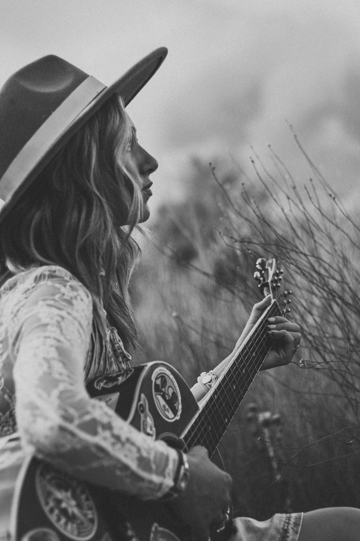 Artistic senior portrait session in Abilene TX featuring a high school senior with a guitar and moody black and white styling