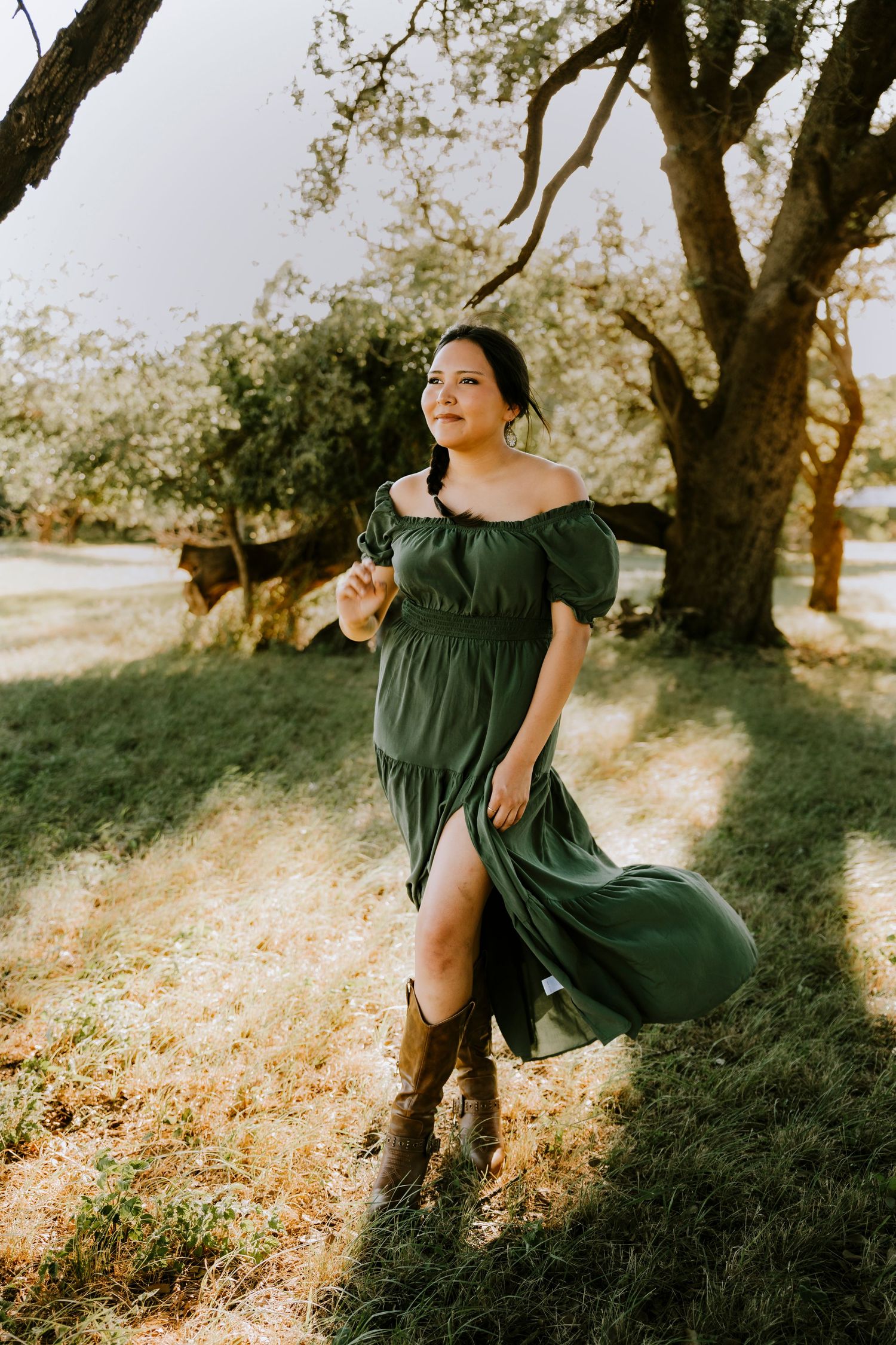 High school senior smiling as her hair catches the golden sunset light during an outdoor senior session in Abilene, Texas