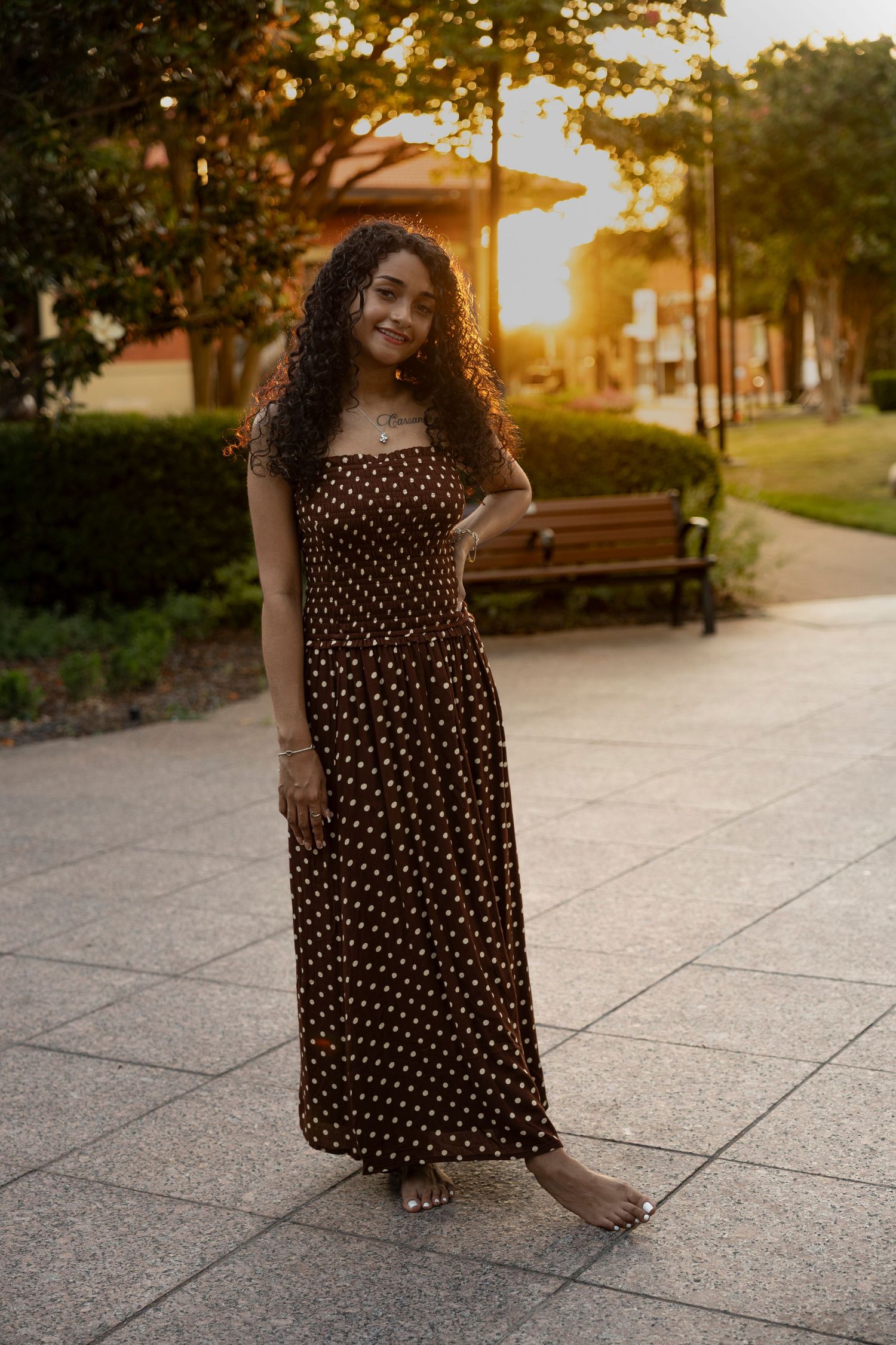 Class of 2027 Cooper High School senior standing in downtown Abilene, Texas with warm sunset light during her senior portrait session.