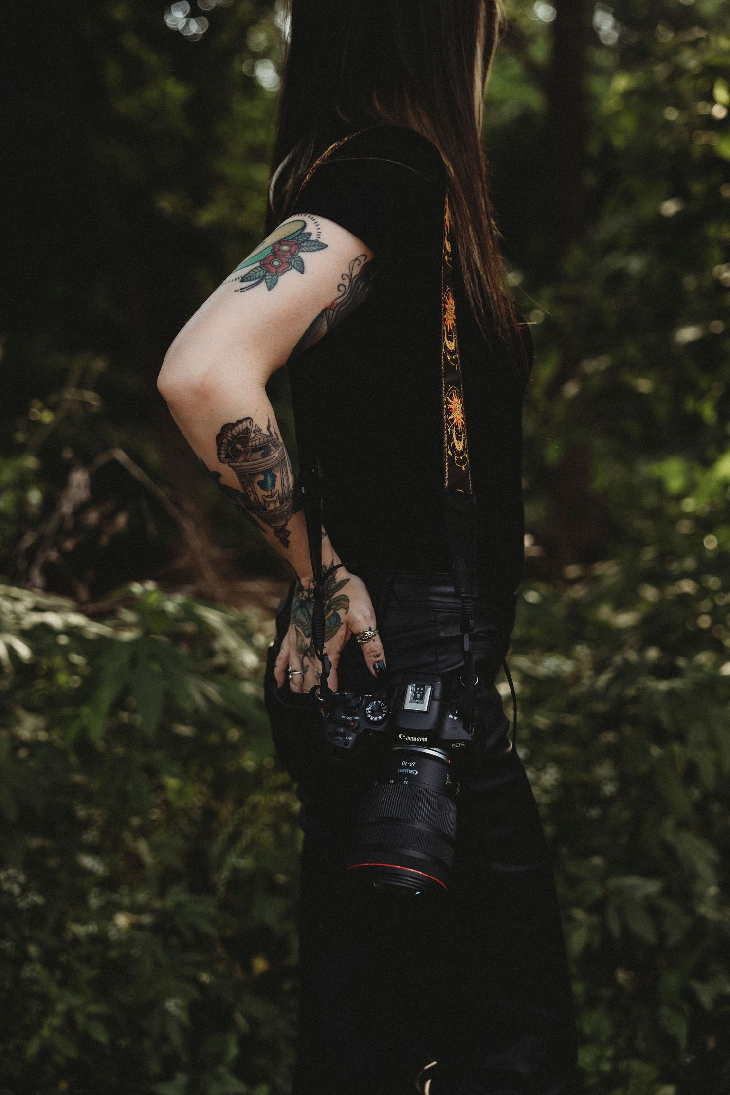 Moody portrait of photographer outdoors with camera, showcasing creative branding and photography identity.