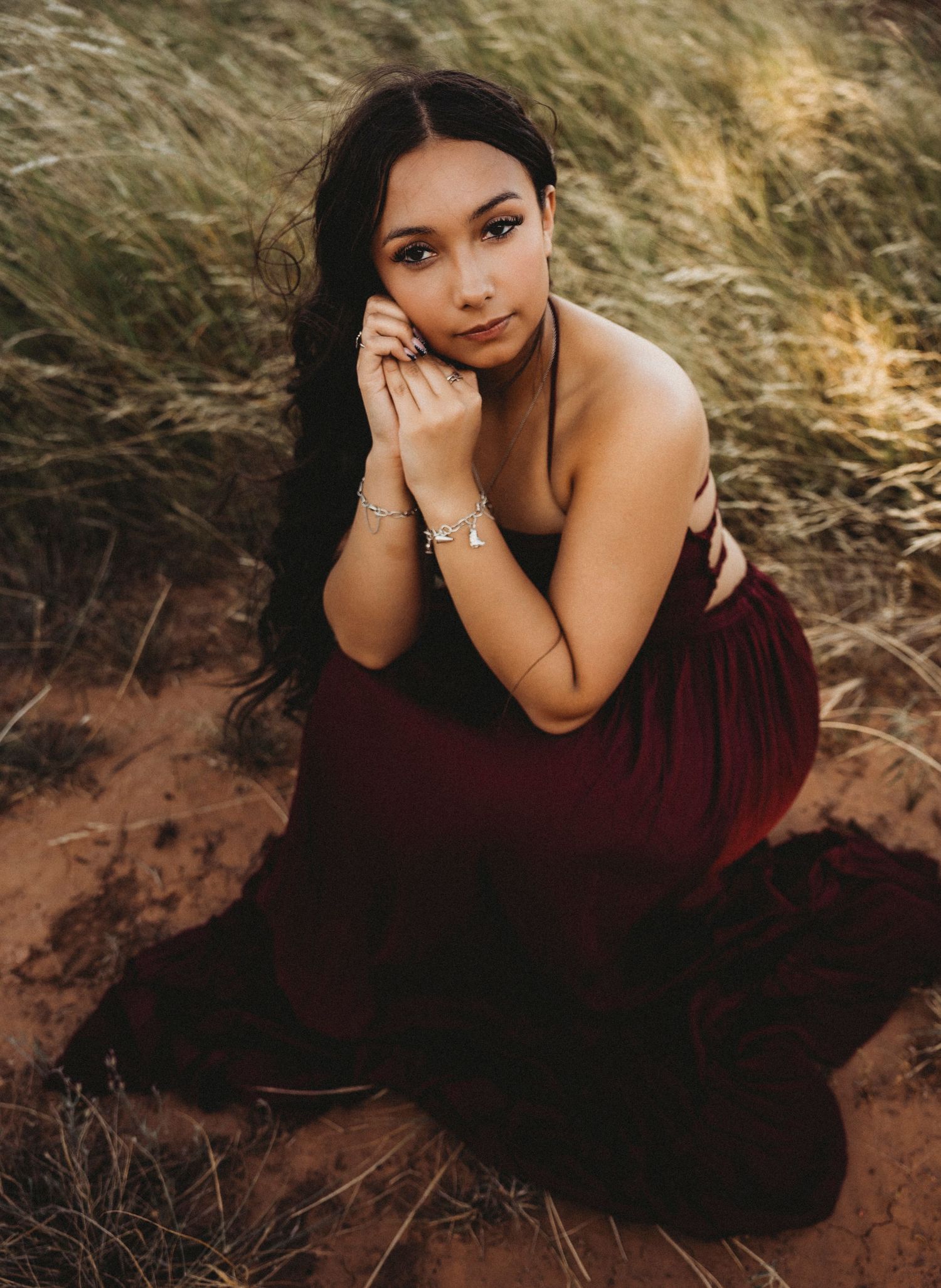 Close-up senior portrait of a Class of 2027 senior in a burgundy dress during an outdoor senior photos session in Abilene, Texas.