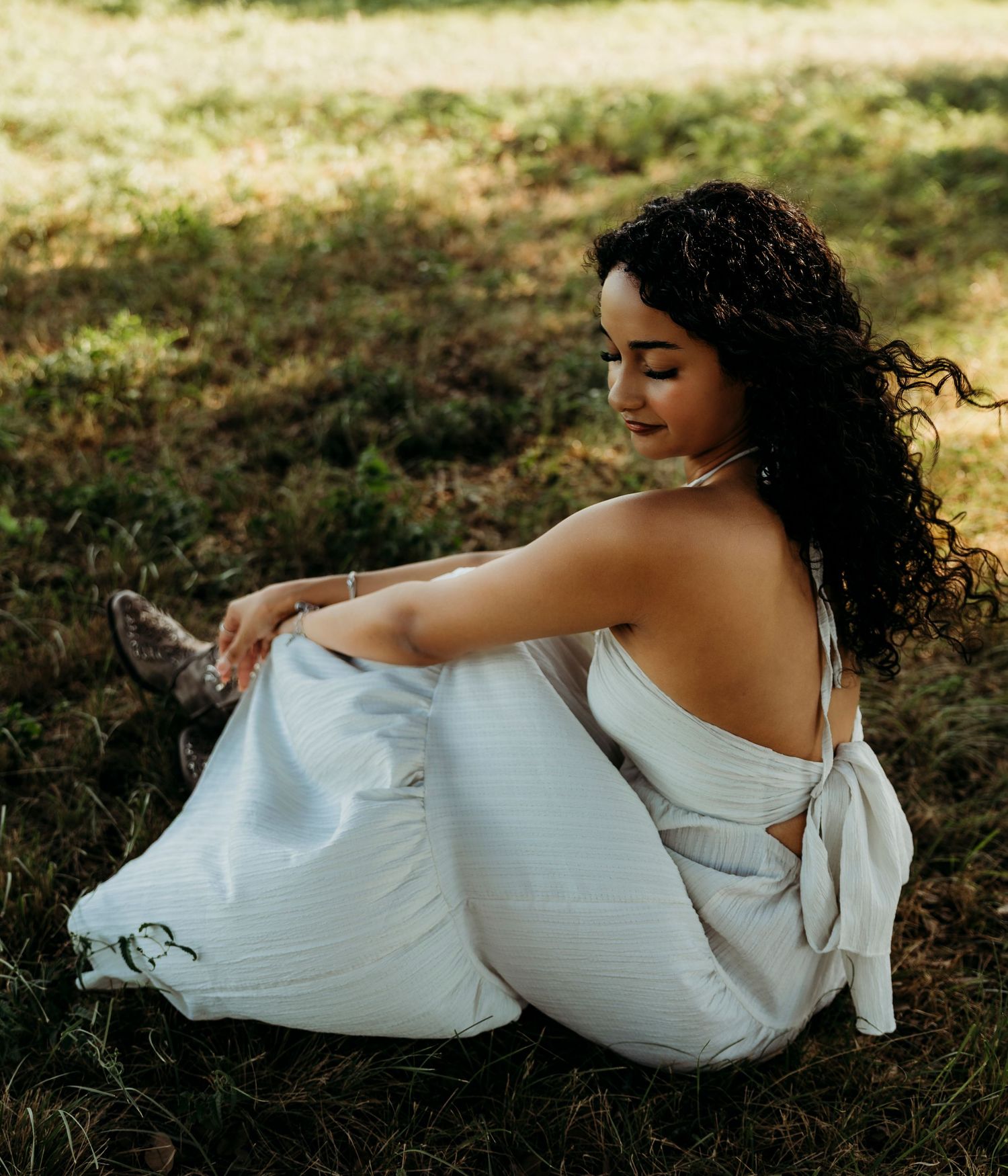 High school senior sitting in a field in Abilene Texas at golden hour photo shoot.