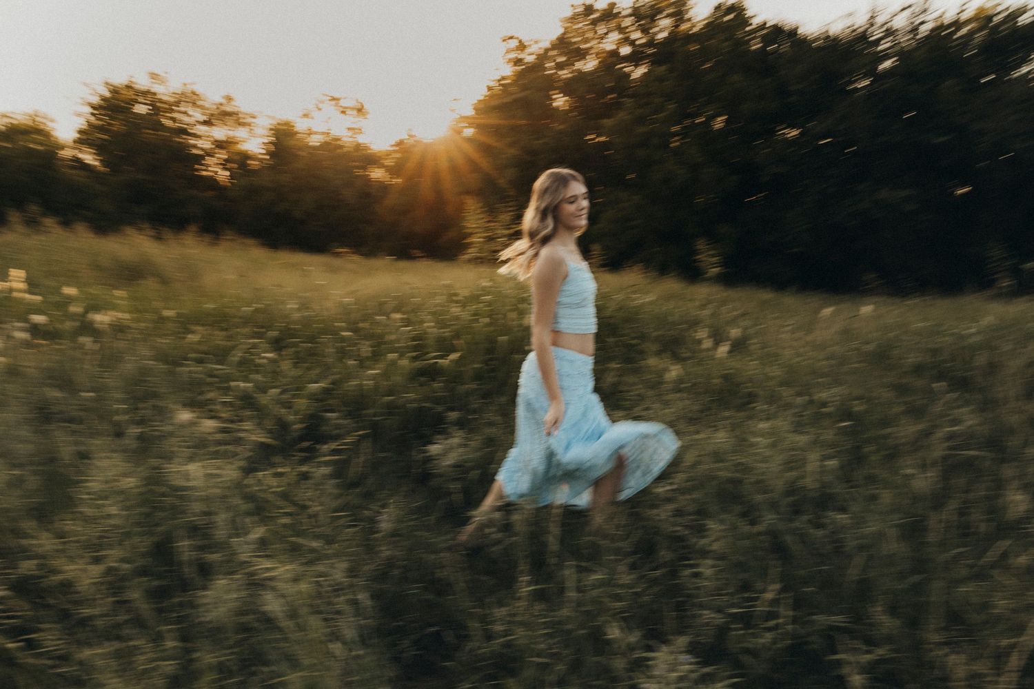 Abilene Texas senior girl walking through a wildflower field at golden hour