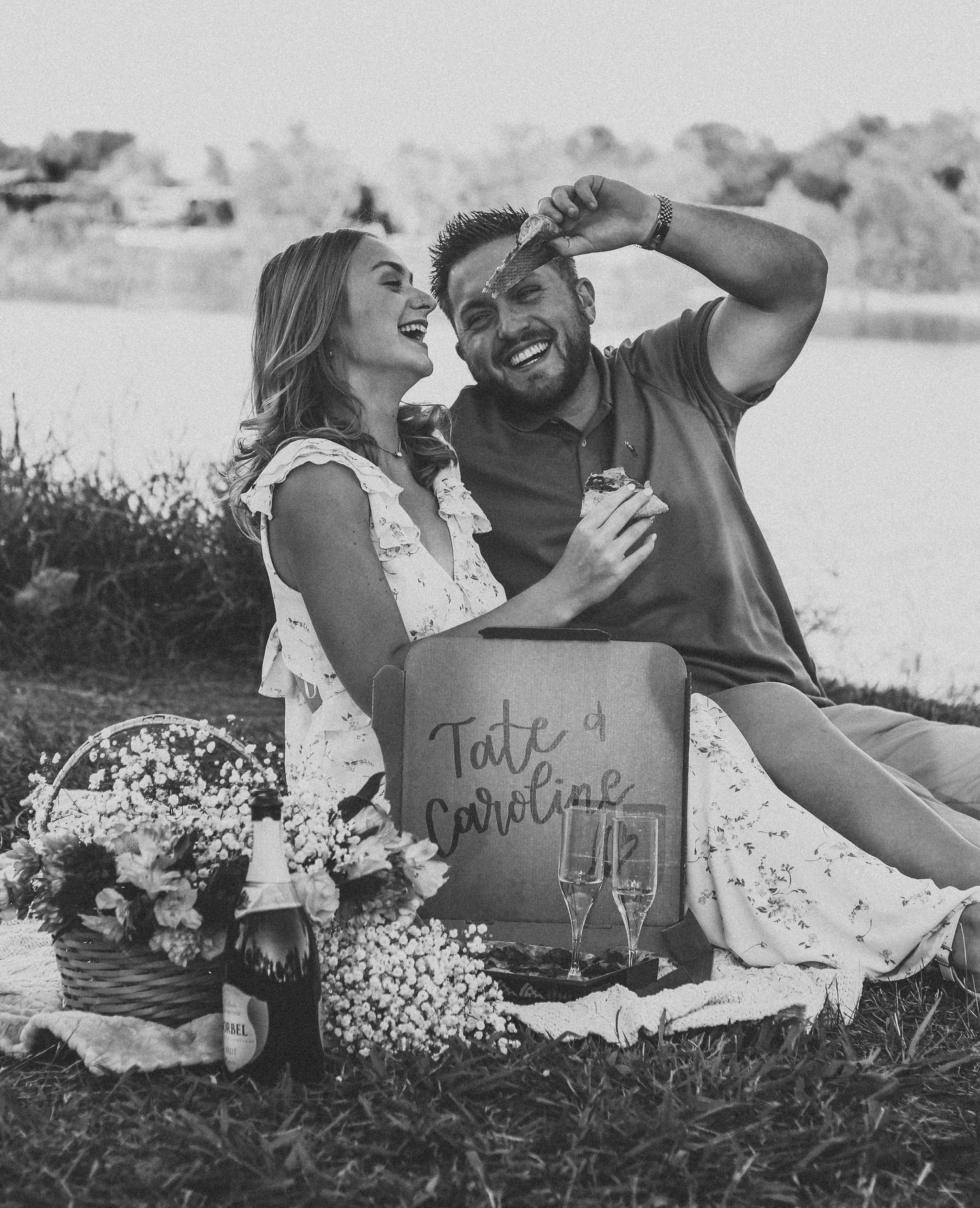 Black and white engagement photo of a couple laughing together during an outdoor engagement session in Abilene, Texas.