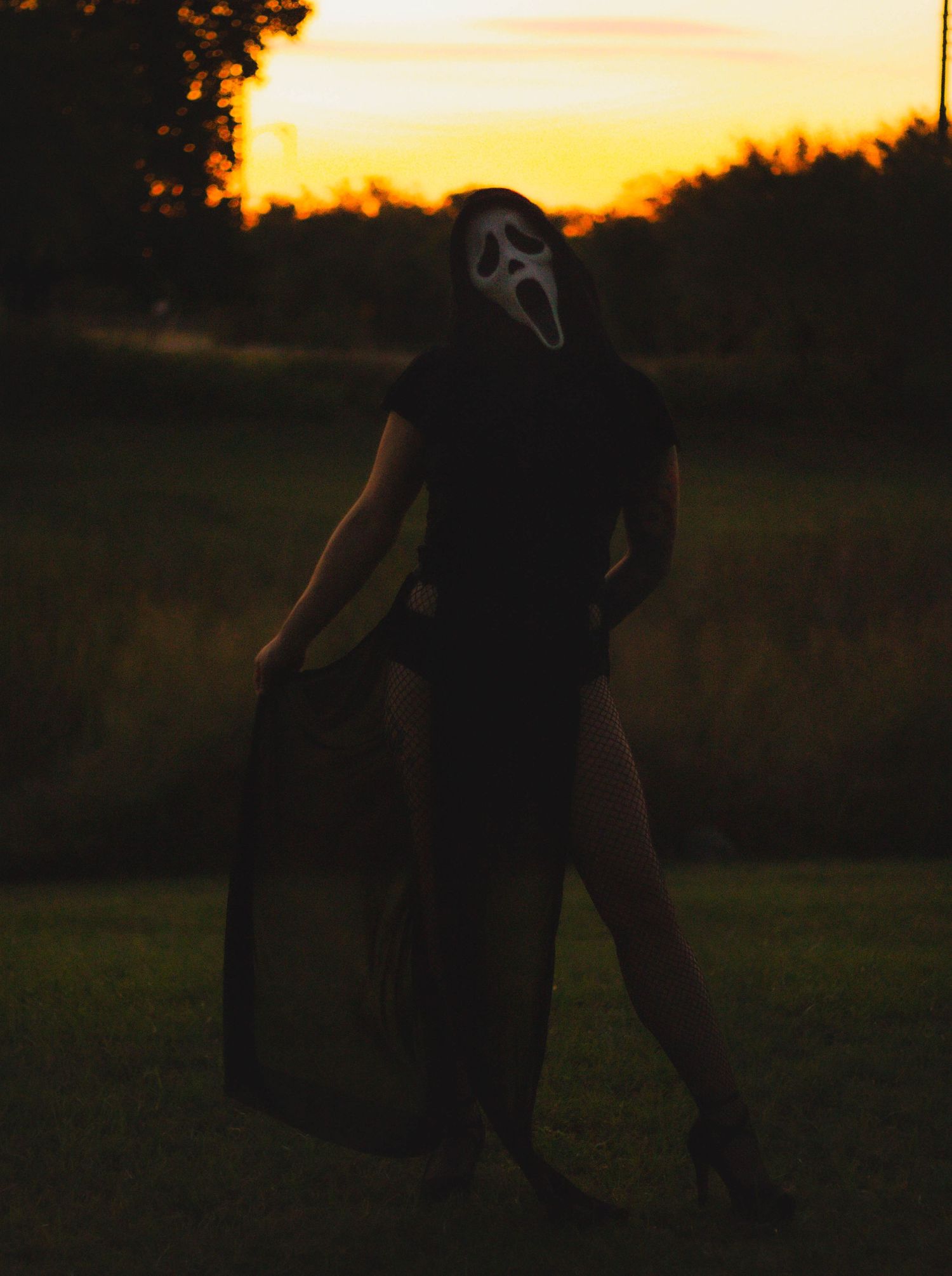 Moody halloween portrait session in Abilene TX with dramatic sunset lighting and flowing dark wardrobe