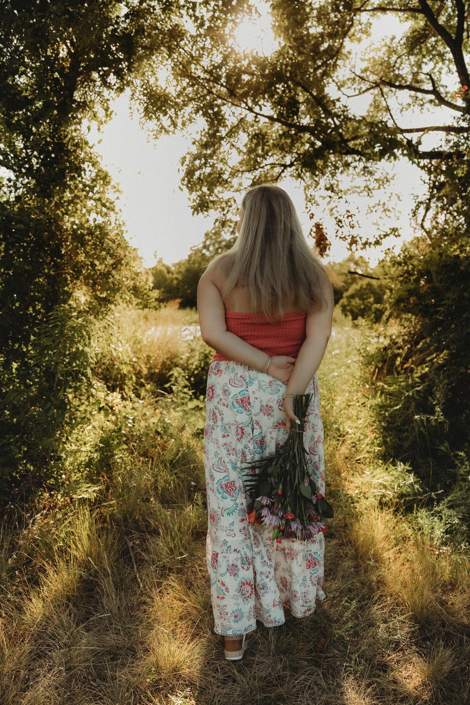 Wylie High School senior walking through a sunlit trail during golden hour senior photos in Abilene, Texas.