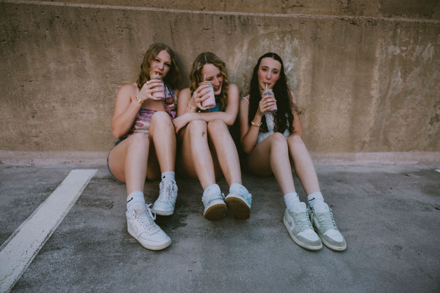 Three friends sitting together and laughing during a bestie photography session