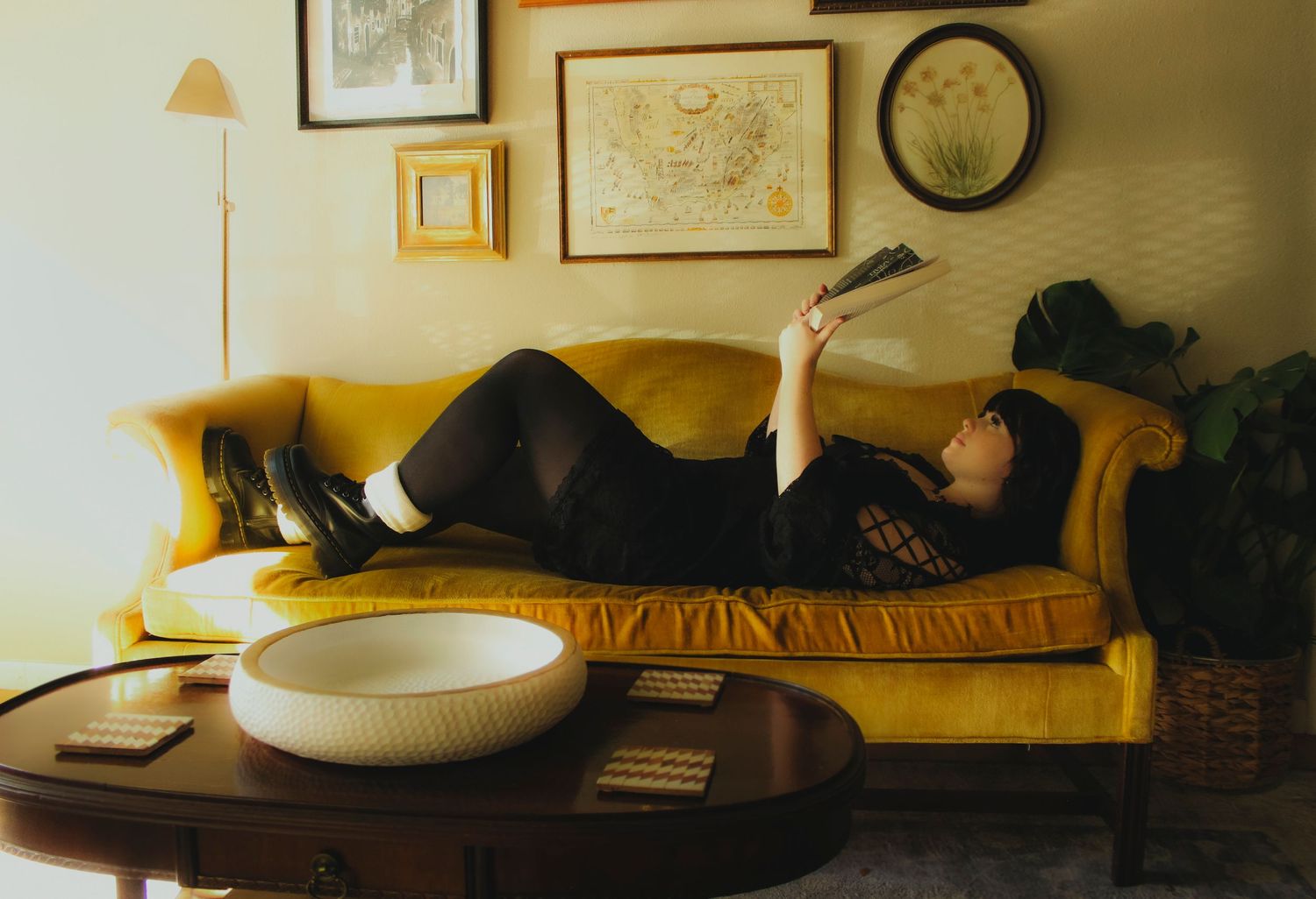 Moody editorial portrait with books and dramatic lighting in library senior session