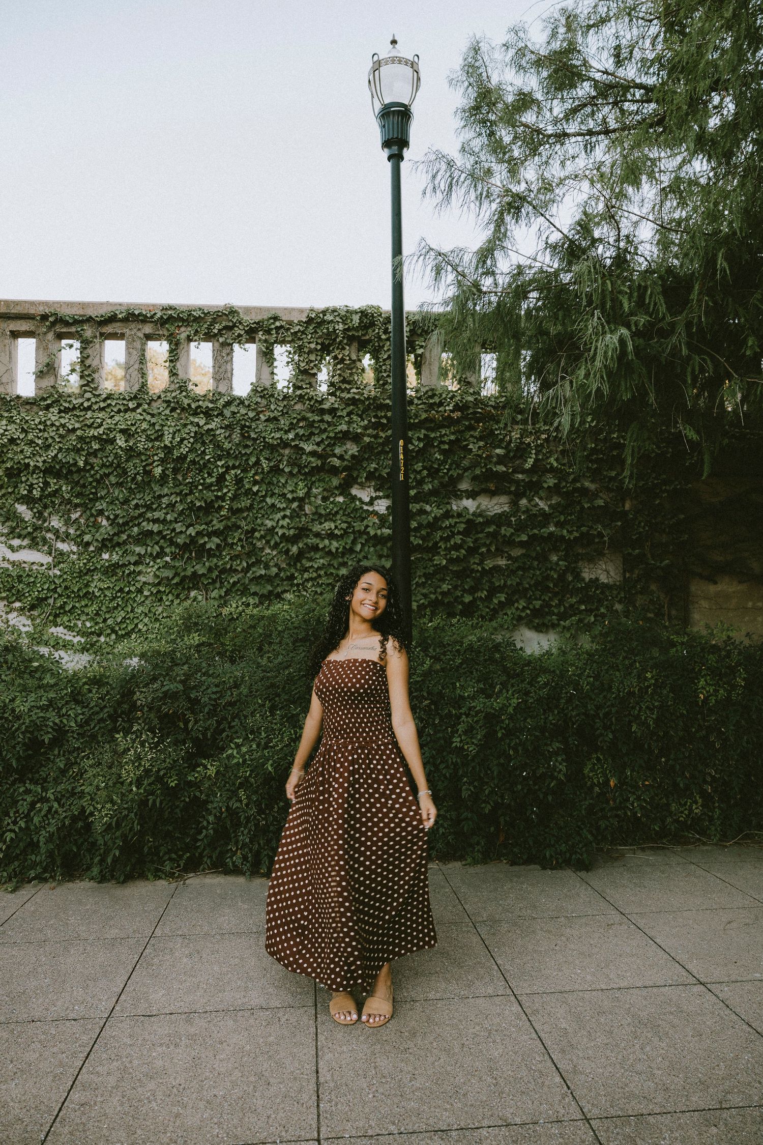 Full-length portrait of a Cooper High School senior surrounded by downtown Abilene scenery during a golden hour senior session.