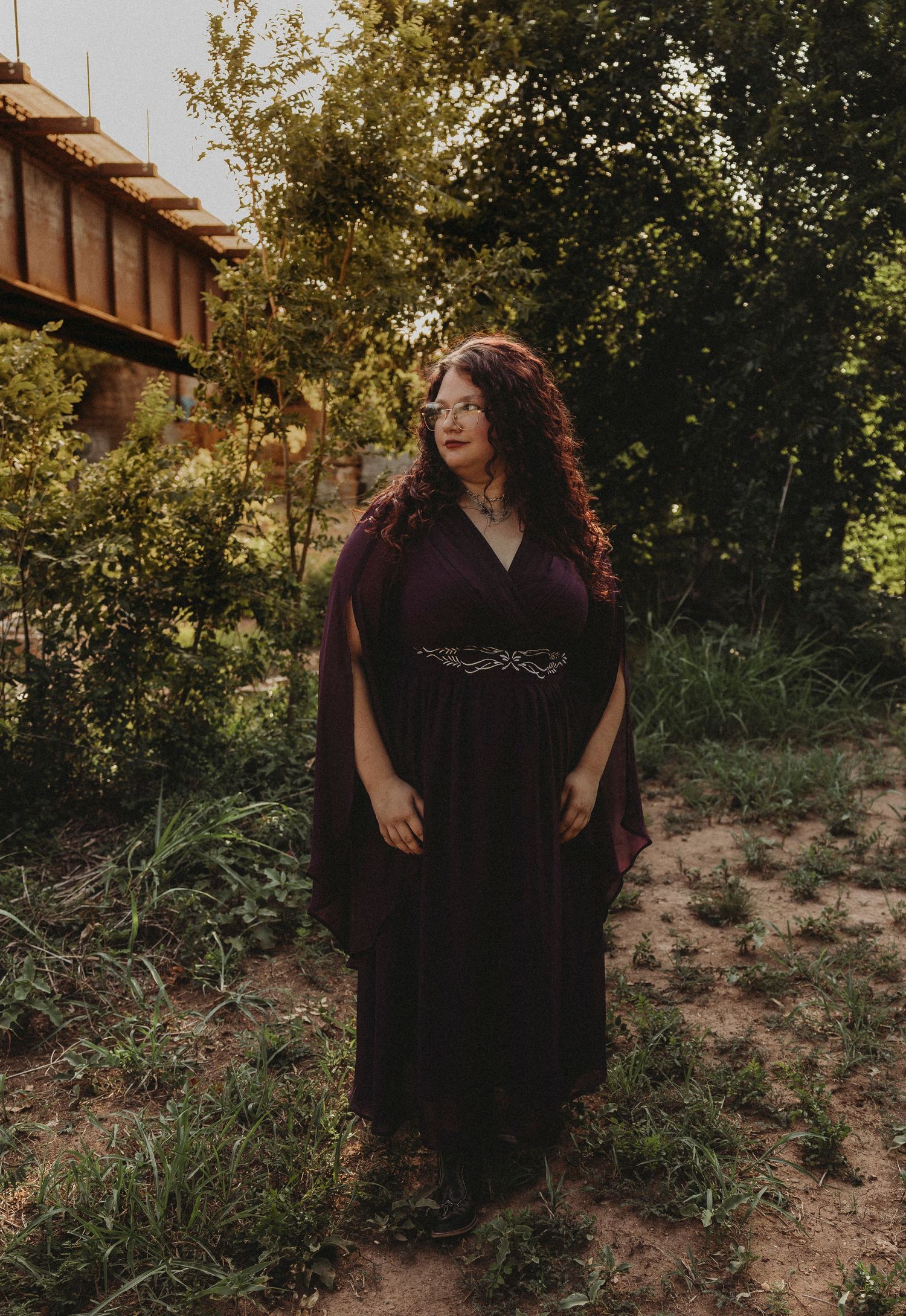 Outdoor senior portrait of a Class of 2027 senior standing beneath trees during a golden hour senior photos session in Abilene, Texas.