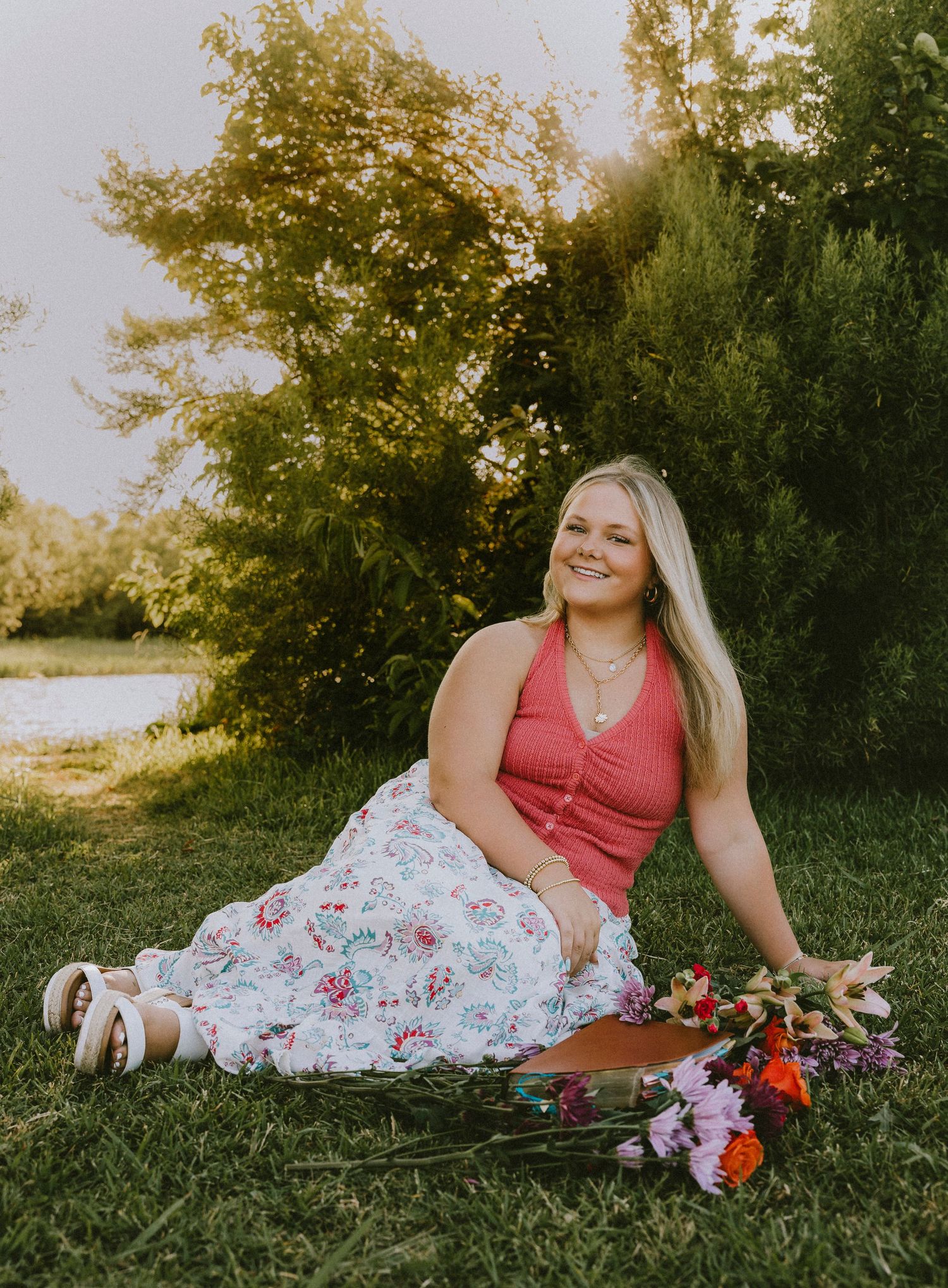 Wylie High School senior posing beside a bouquet of flowers during a golden hour senior portrait session in Abilene, Texas.