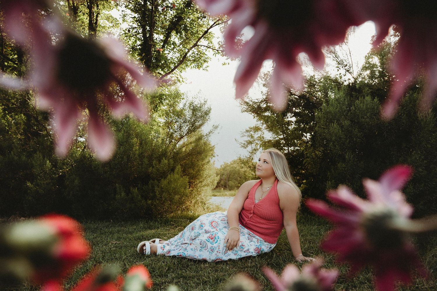 Creative senior photos of a Class of 2027 senior framed by flowers during a golden hour outdoor senior portrait session in Abilene, Texas.