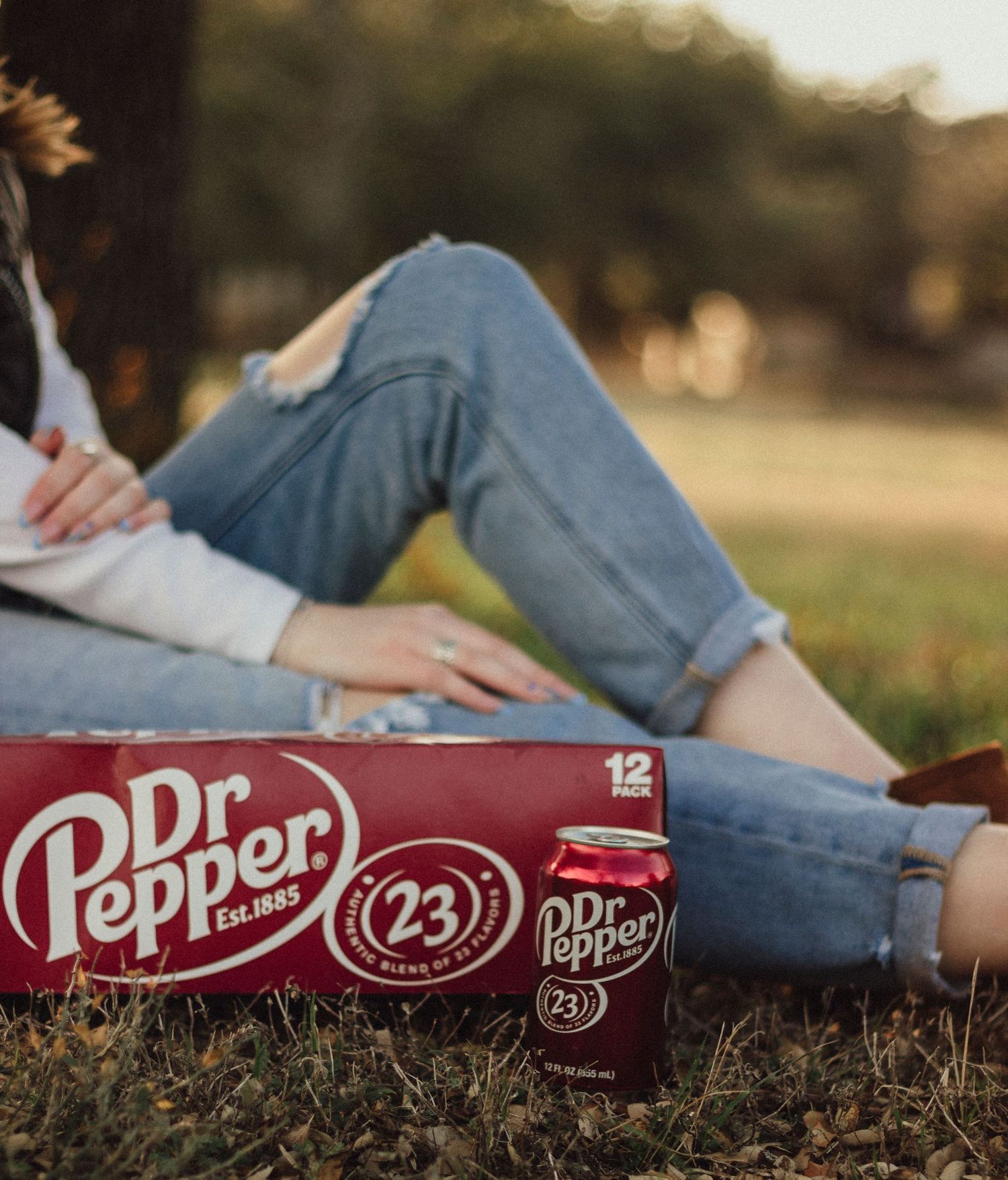 Senior girl sitting outdoors with Dr Pepper crates during a senior photo session in Abilene, Texas.