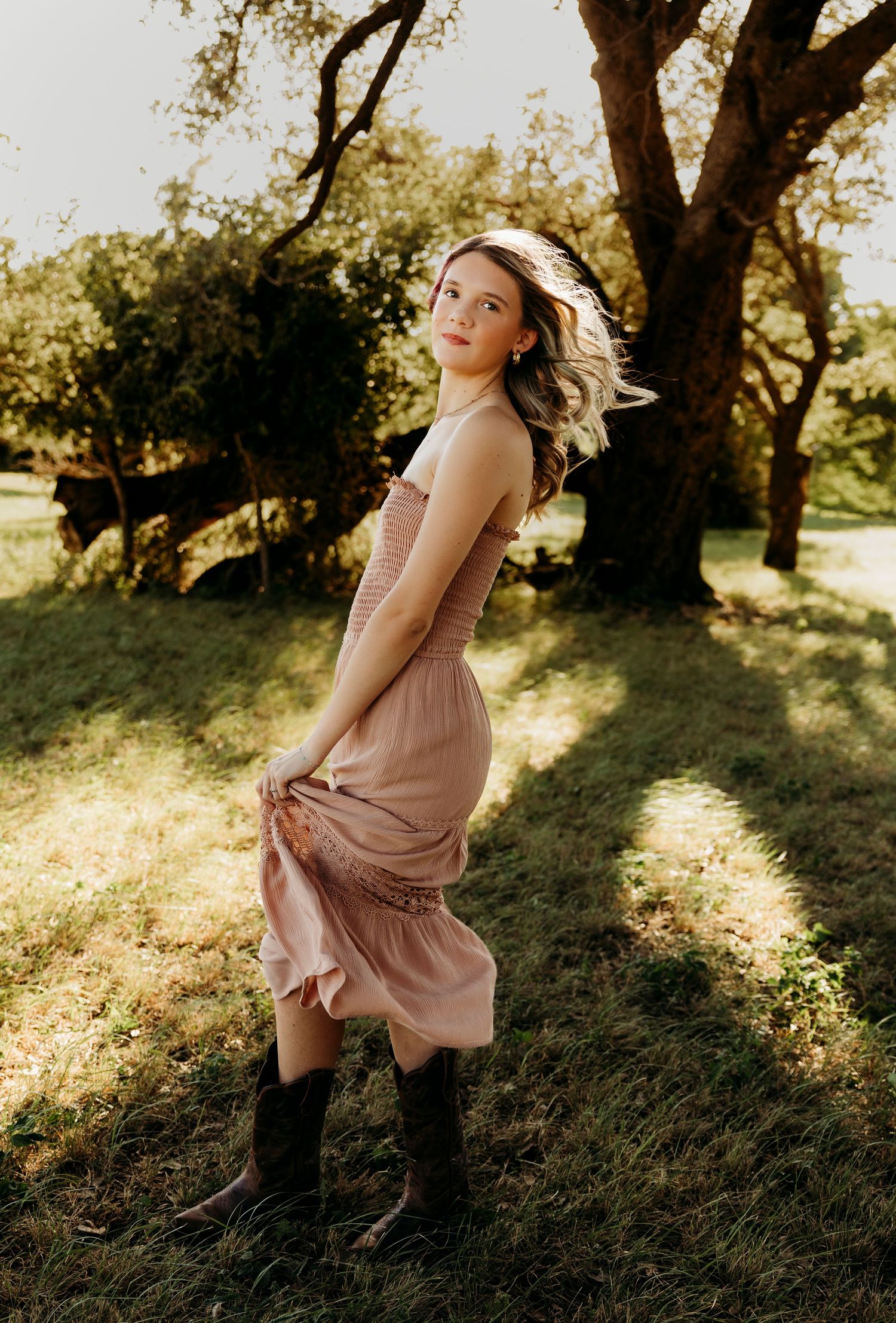 Golden hour senior portrait of a Class of 2027 senior in a flowing mauve dress during an outdoor senior session