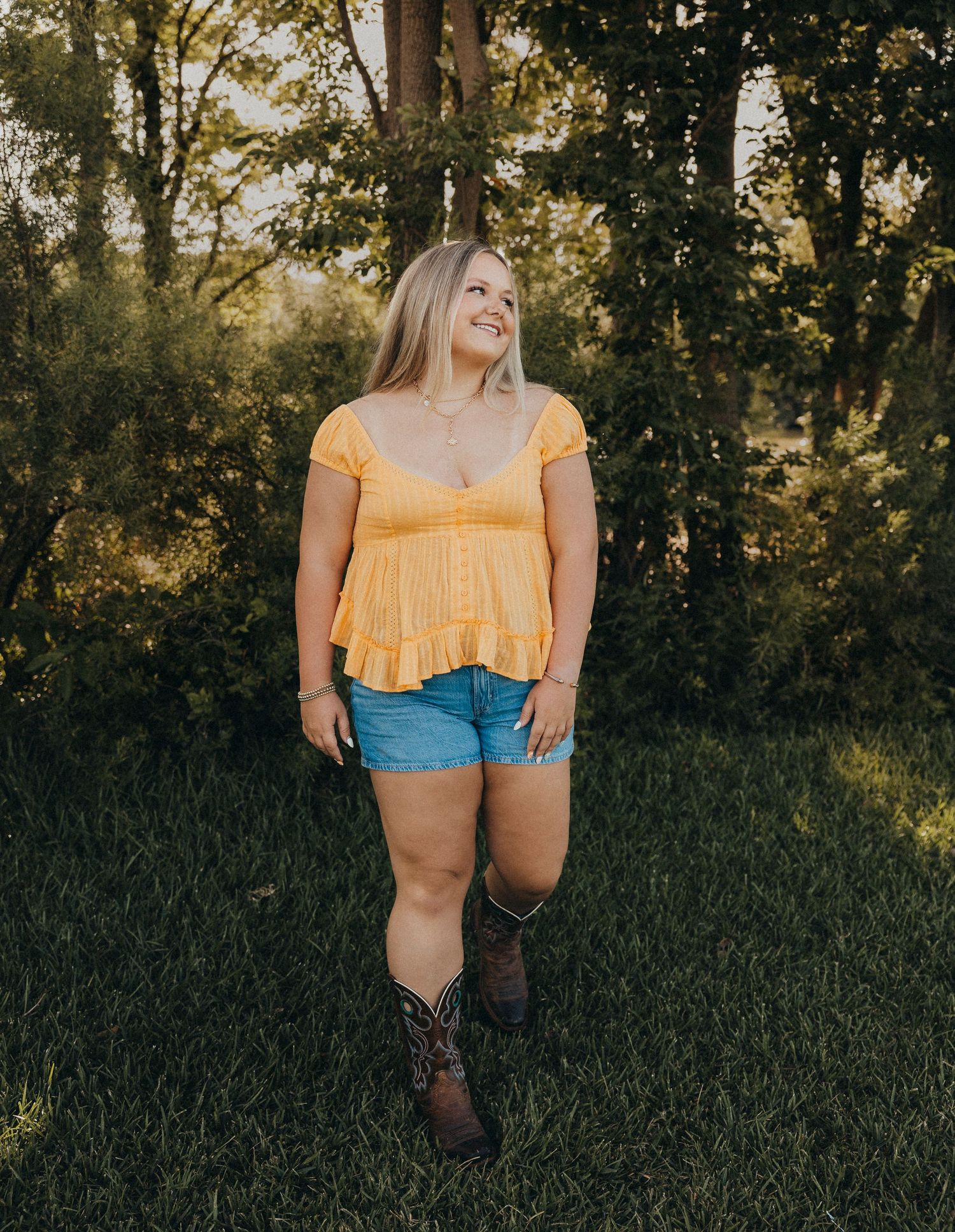 Outdoor senior photos of a Class of 2027 senior in a yellow top and cowboy boots during a golden hour senior portrait session in Abilene, Tx