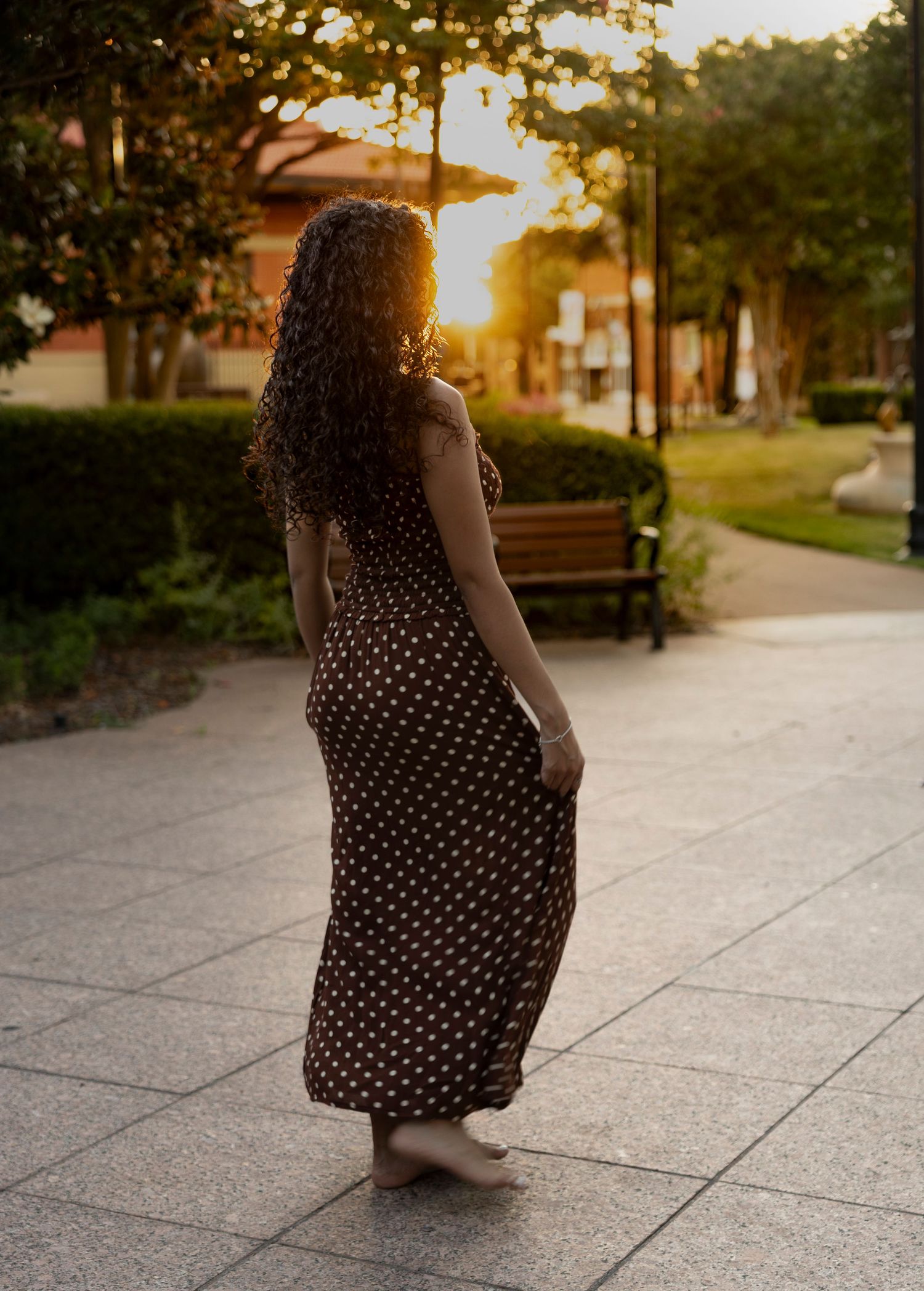 Cooper High School senior walking through downtown Abilene, Texas at sunset during her Class of 2027 senior portrait session.