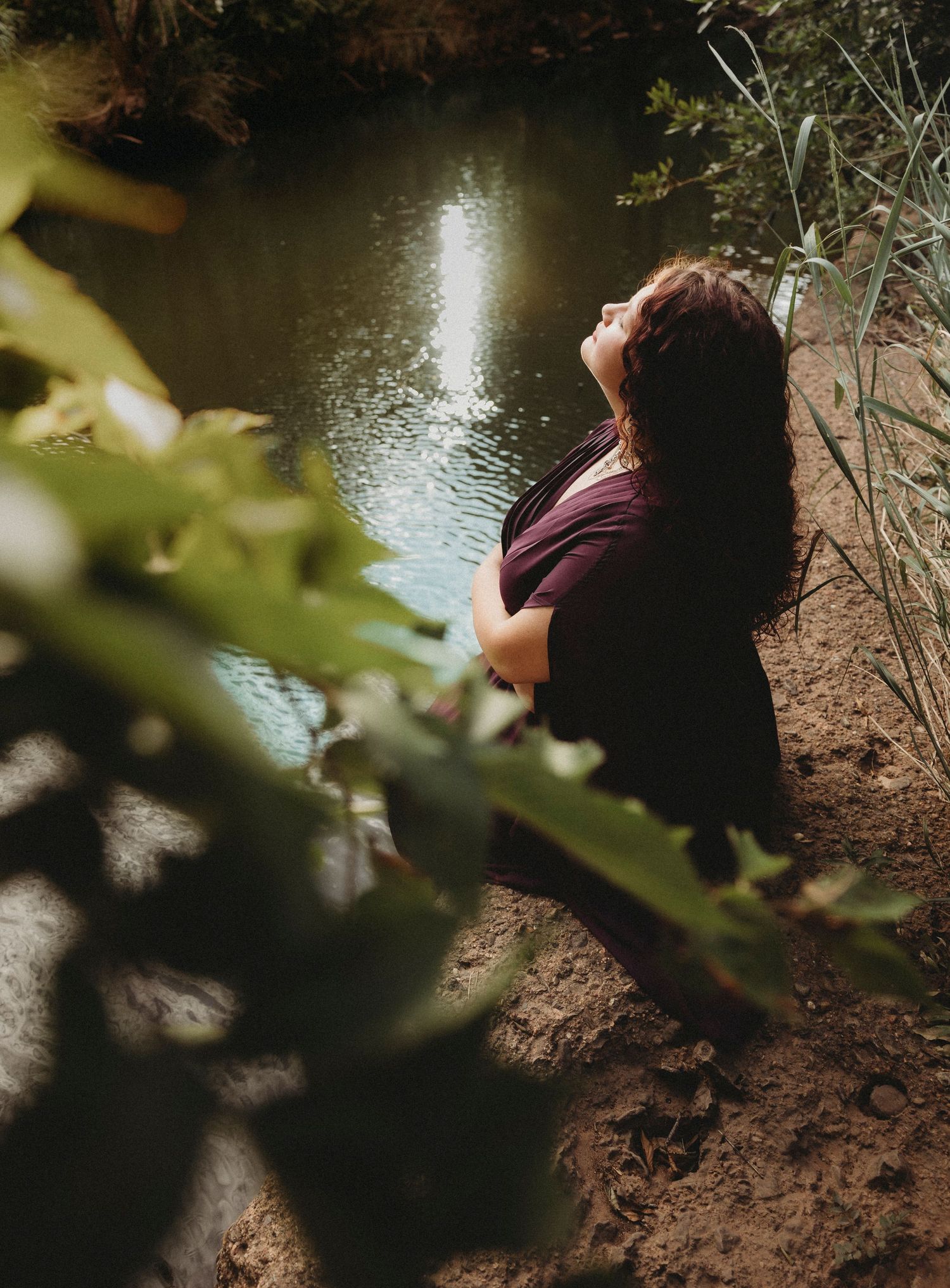 Jim Ned High School Class of 2027 senior sitting by a quiet creek during a whimsical outdoor senior portrait session