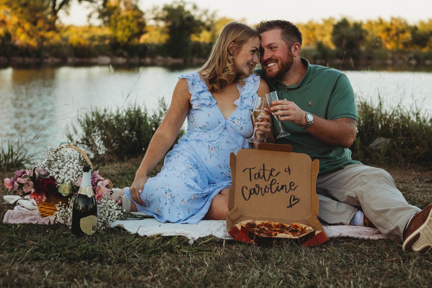 Romantic engagement photography session in Abilene, Texas with a couple sitting by the water at sunset.