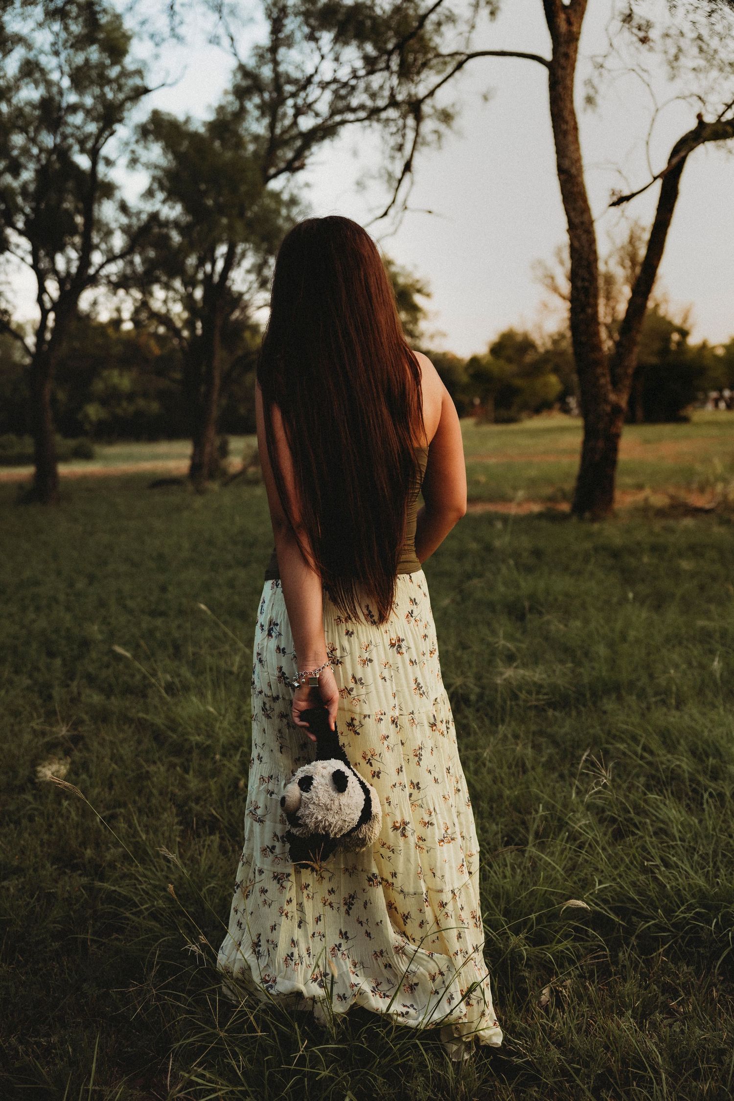 stuffy and Class of 2027 senior in a floral dress during a golden hour senior session in Abilene, Texas.