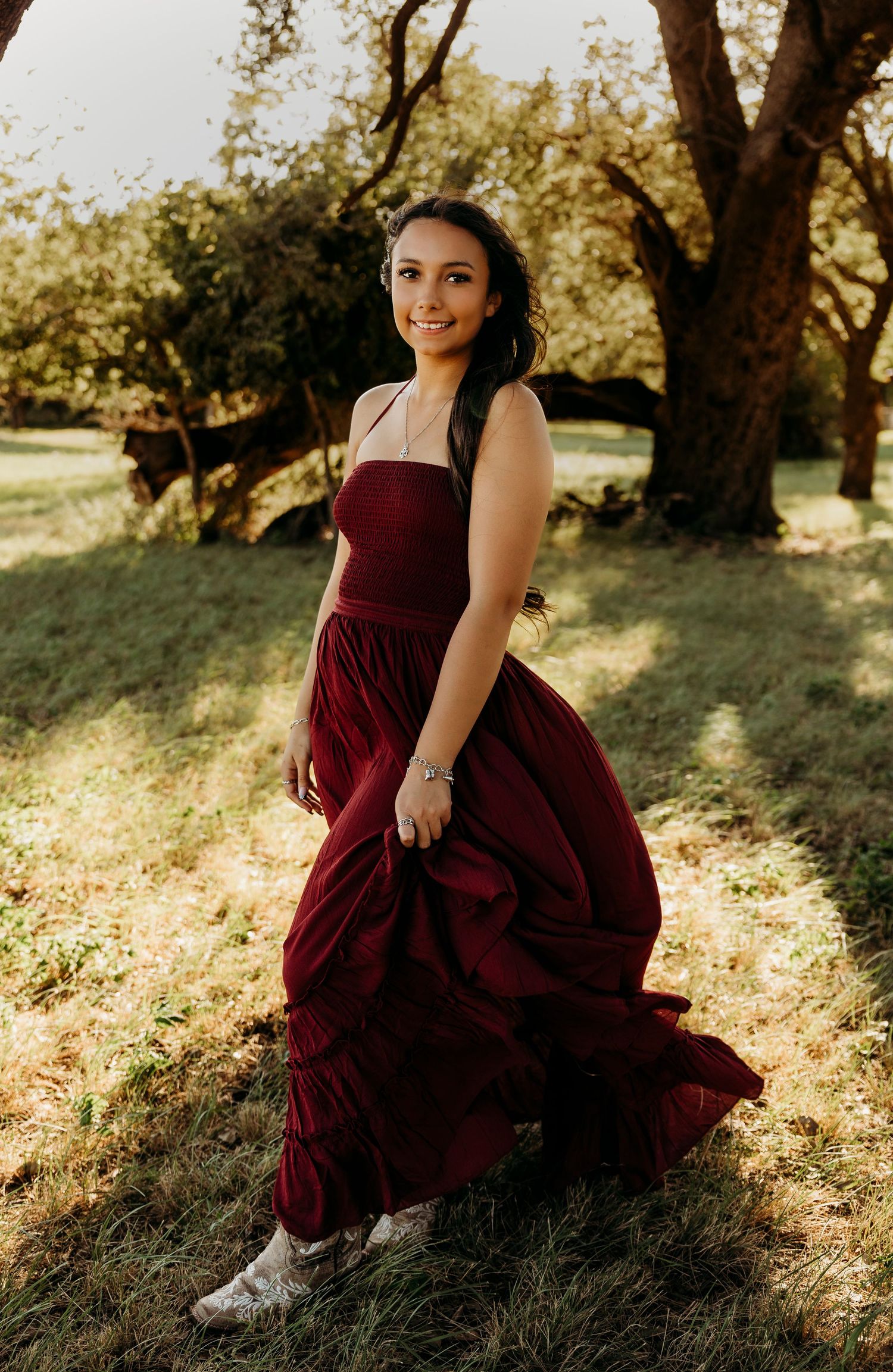 Outdoor senior portraits of a Class of 2027 senior in a burgundy dress during a golden hour senior photos session in Abilene, Texas.