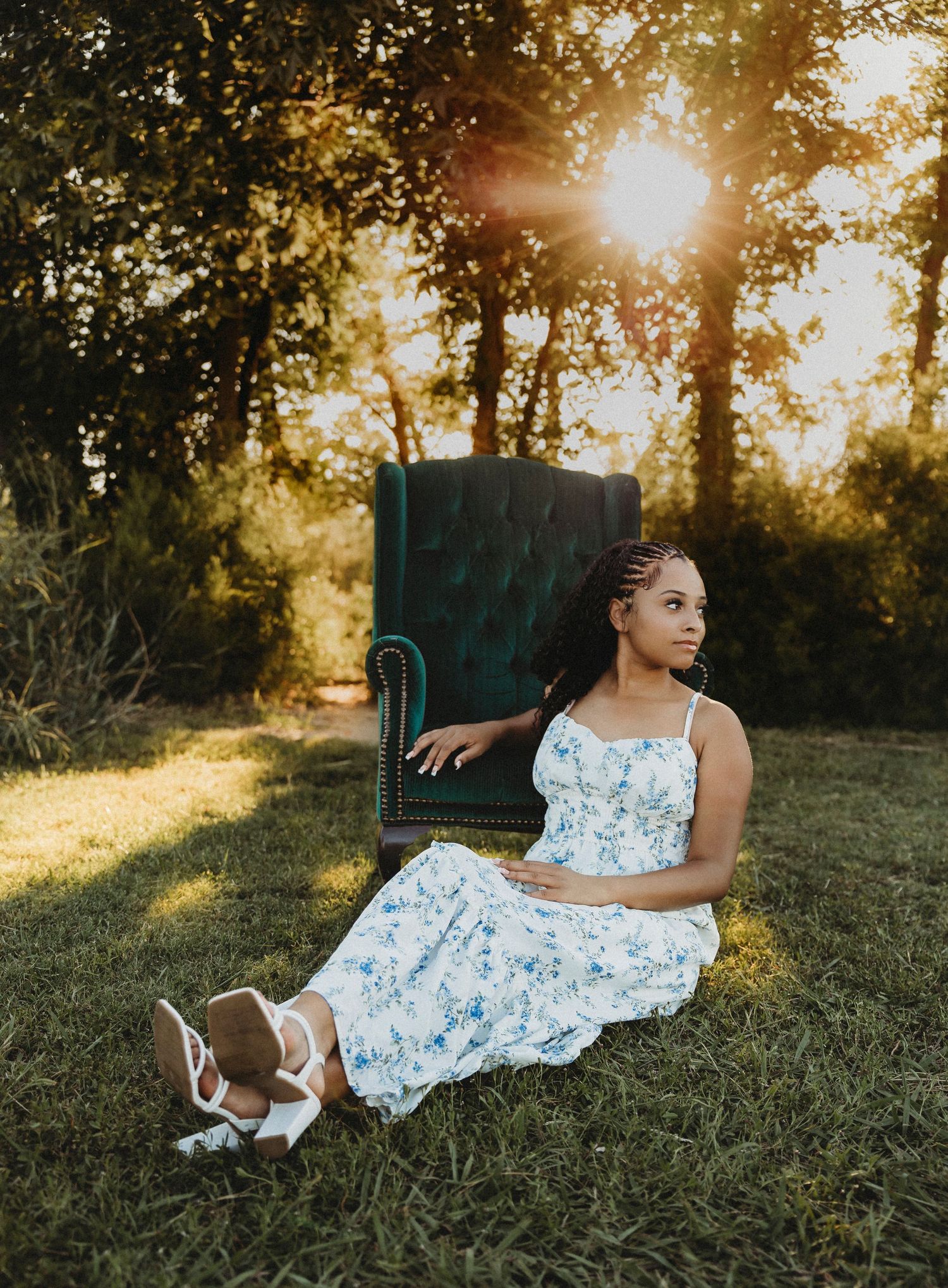 Cooper High School senior relaxing beside a vintage green velvet chair at sunset during a creative outdoor mini session in Abilene, Texas.