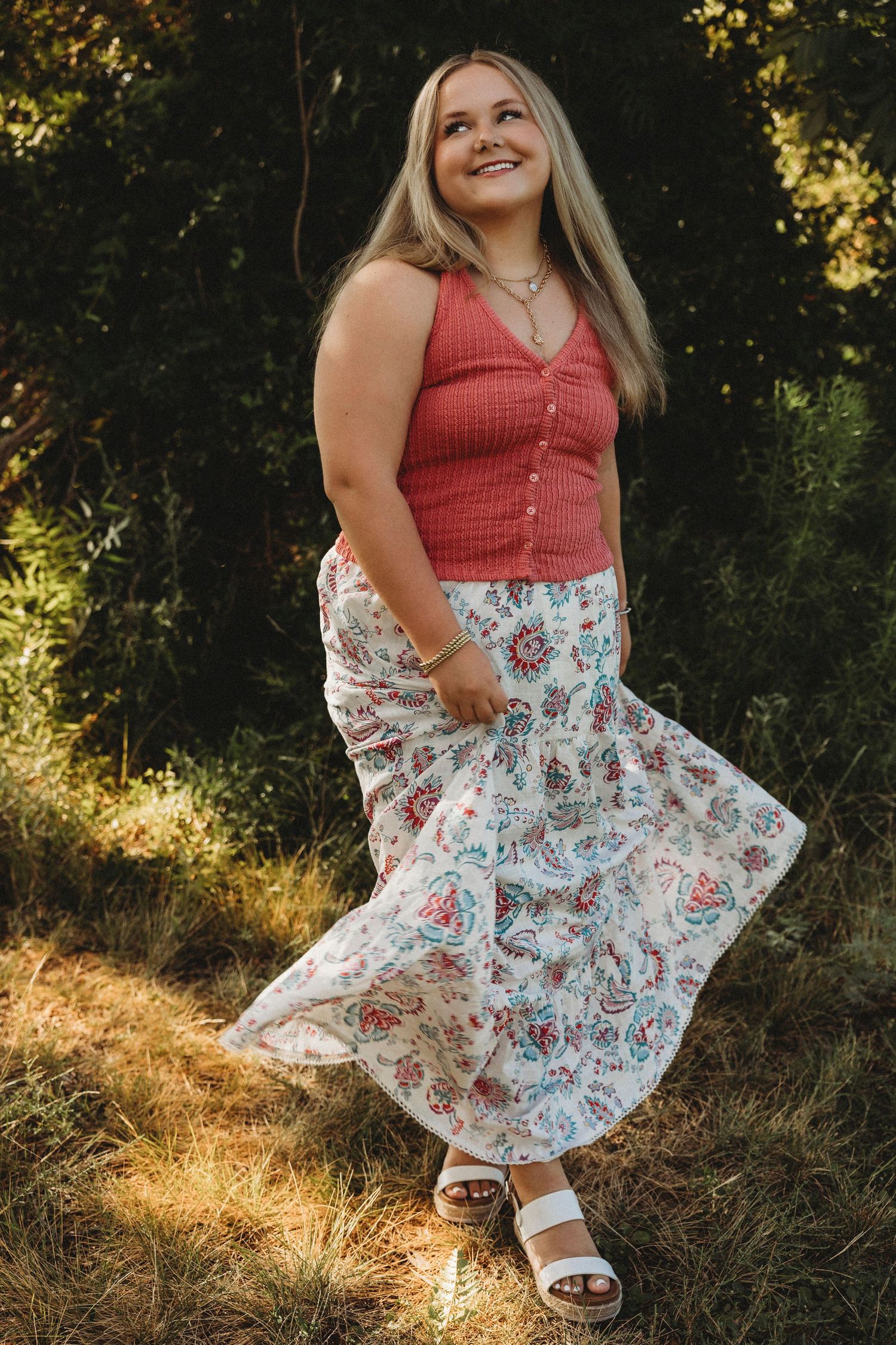 Outdoor senior portrait of a Wylie High School Class of 2027 senior twirling in a floral skirt during golden hour in Abilene, Texas.