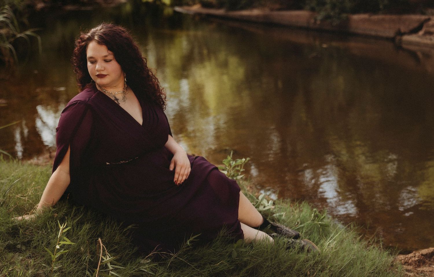 Jim Ned High School Class of 2027 senior sitting by a quiet creek during a whimsical outdoor senior portrait session