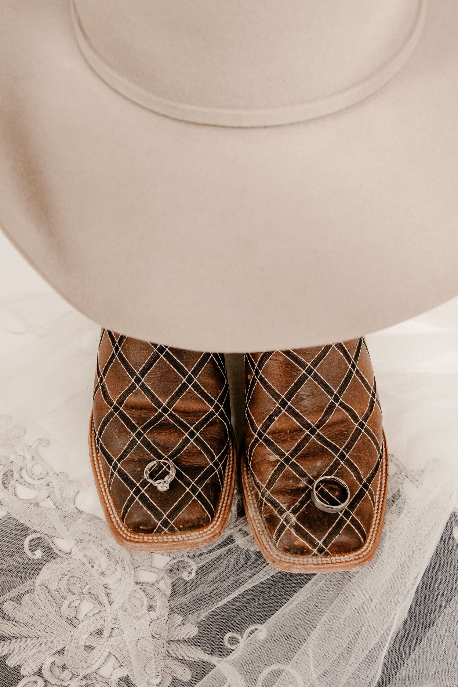 Brown plaid slippers on white lace with cream colored hat above.
