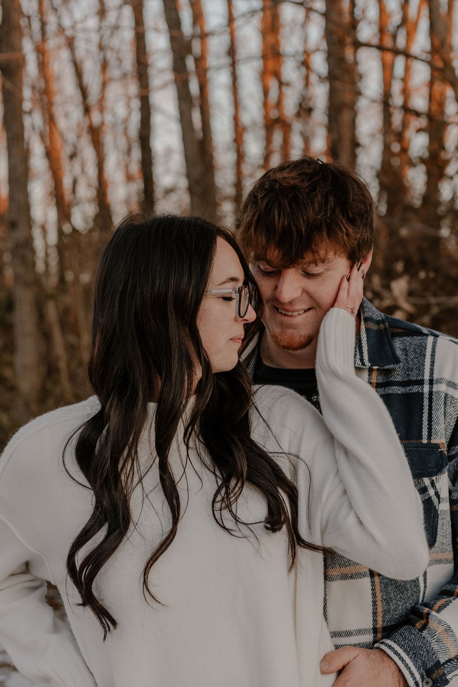 Intimate couple portrait in a forest with warm autumn lighting.