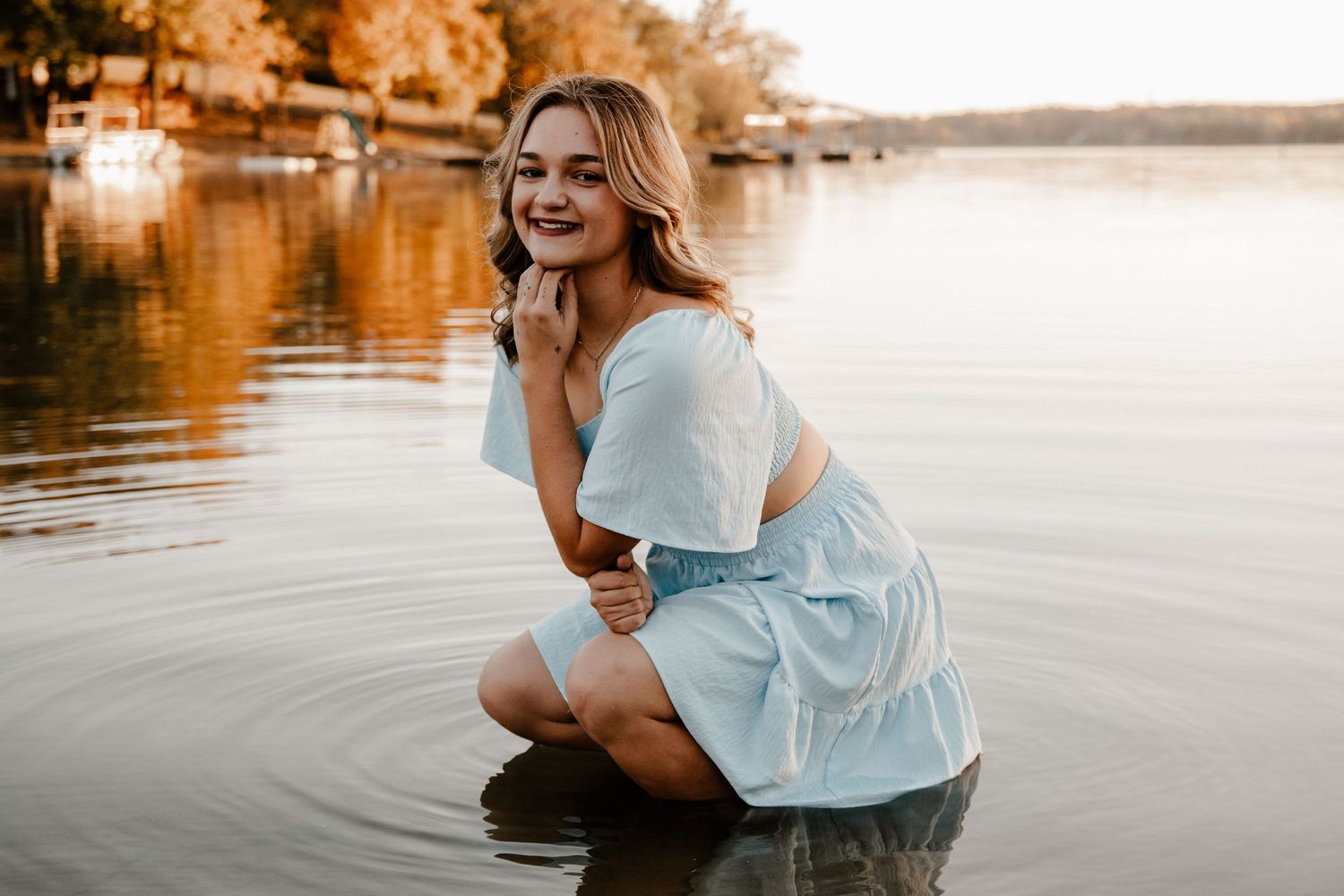 Dreamy waterside photoshoot with white blouse at golden hour.