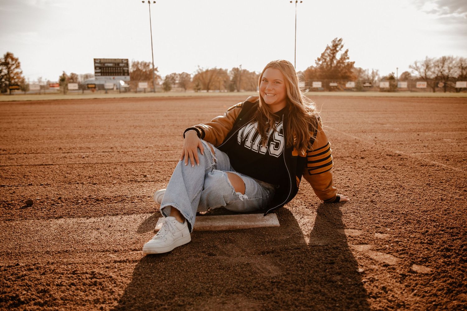 Vintage-style baseball field photoshoot with warm sepia tones and long shadows.