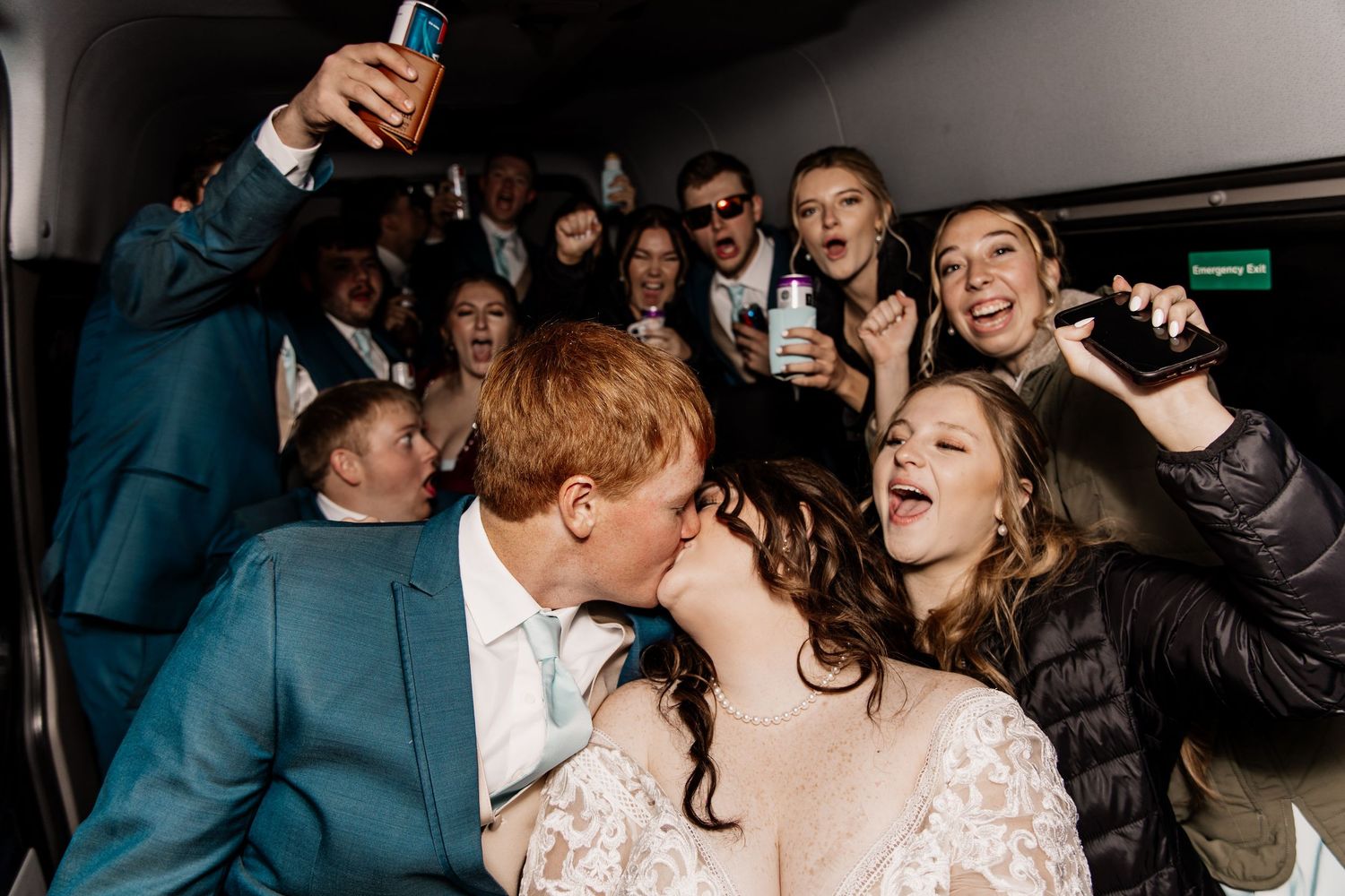 Wedding reception party scene with guests dancing and celebrating in dimly lit venue.