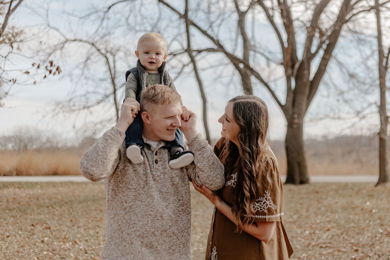 Candid family moments captured in natural outdoor setting during fall.
