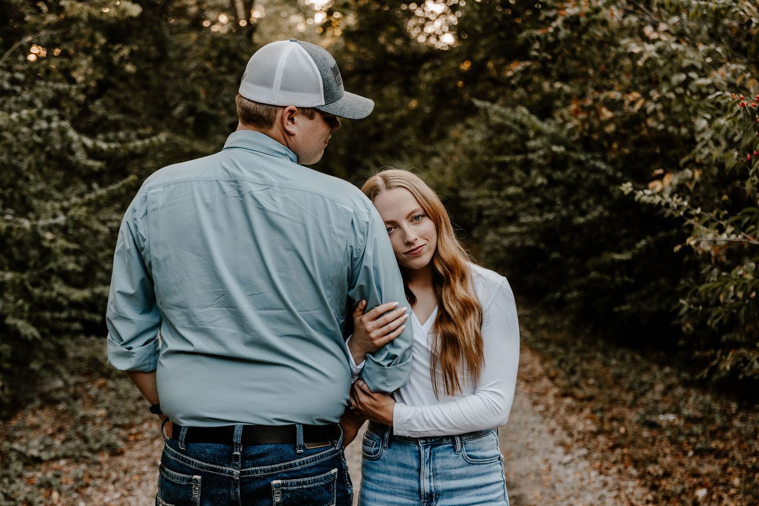 Couple walking together on autumn forest path at sunset.
