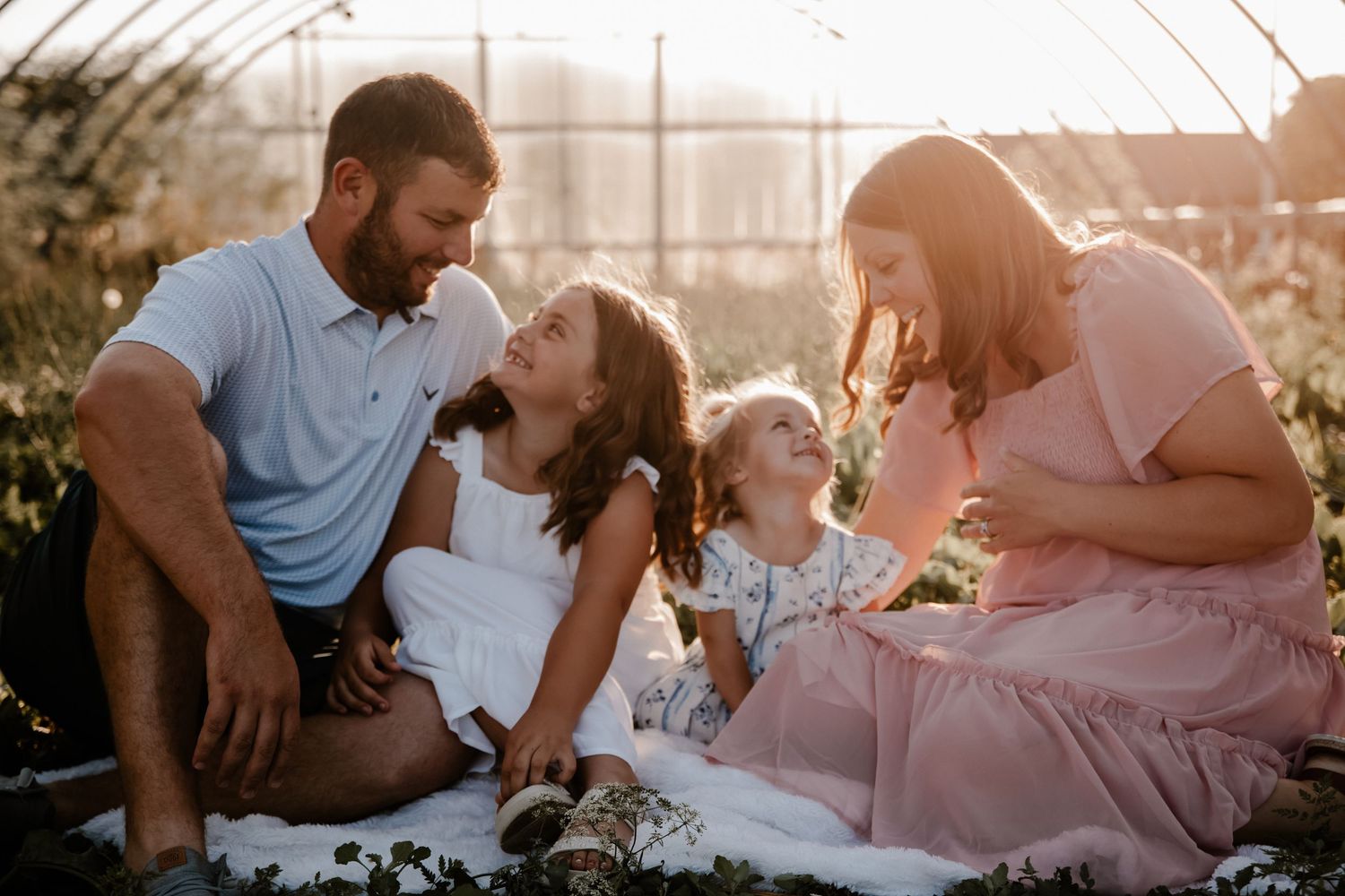 Family enjoying picnic together during golden hour outdoor photoshoot.