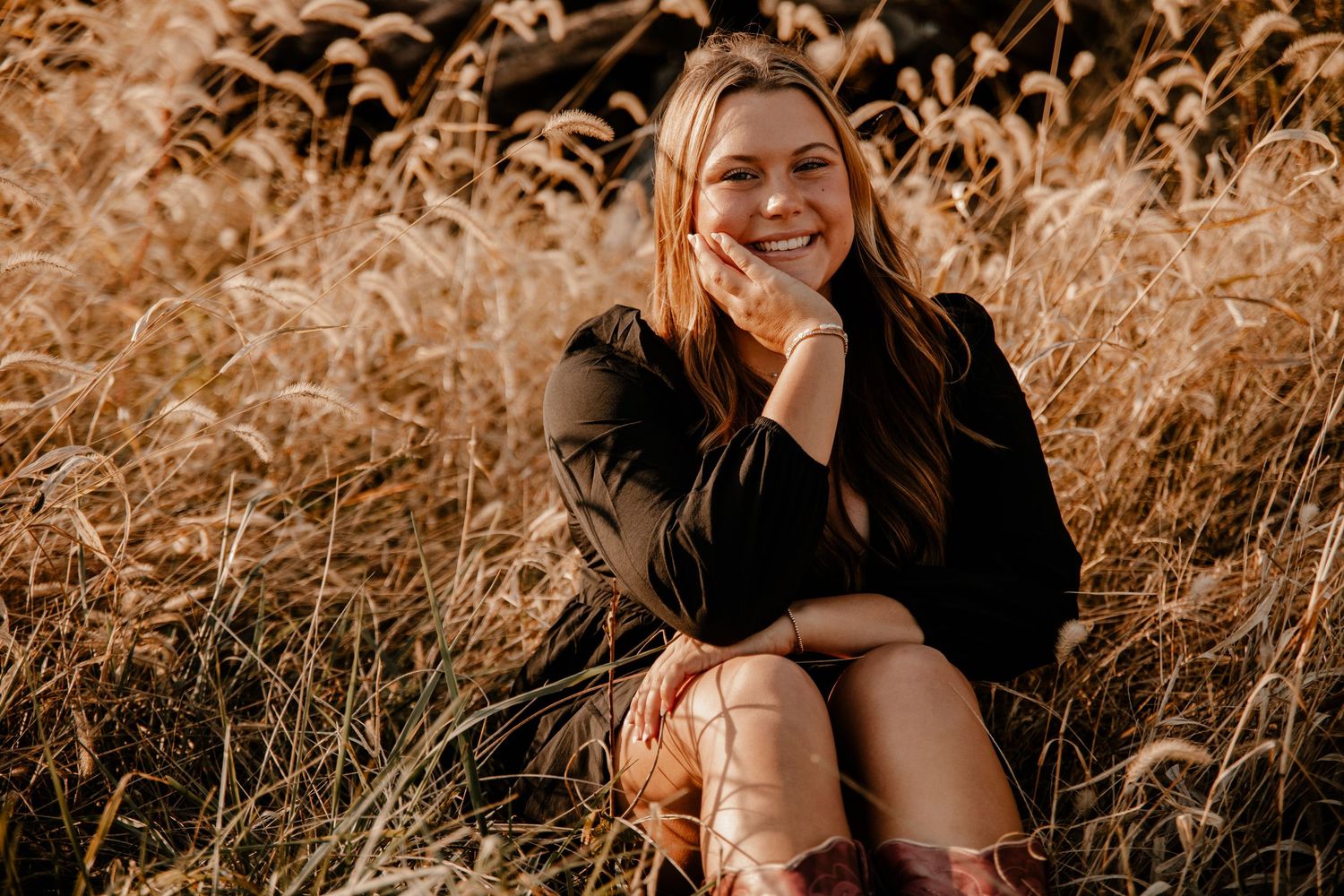 Golden hour portrait session in tall grass with warm autumn lighting.