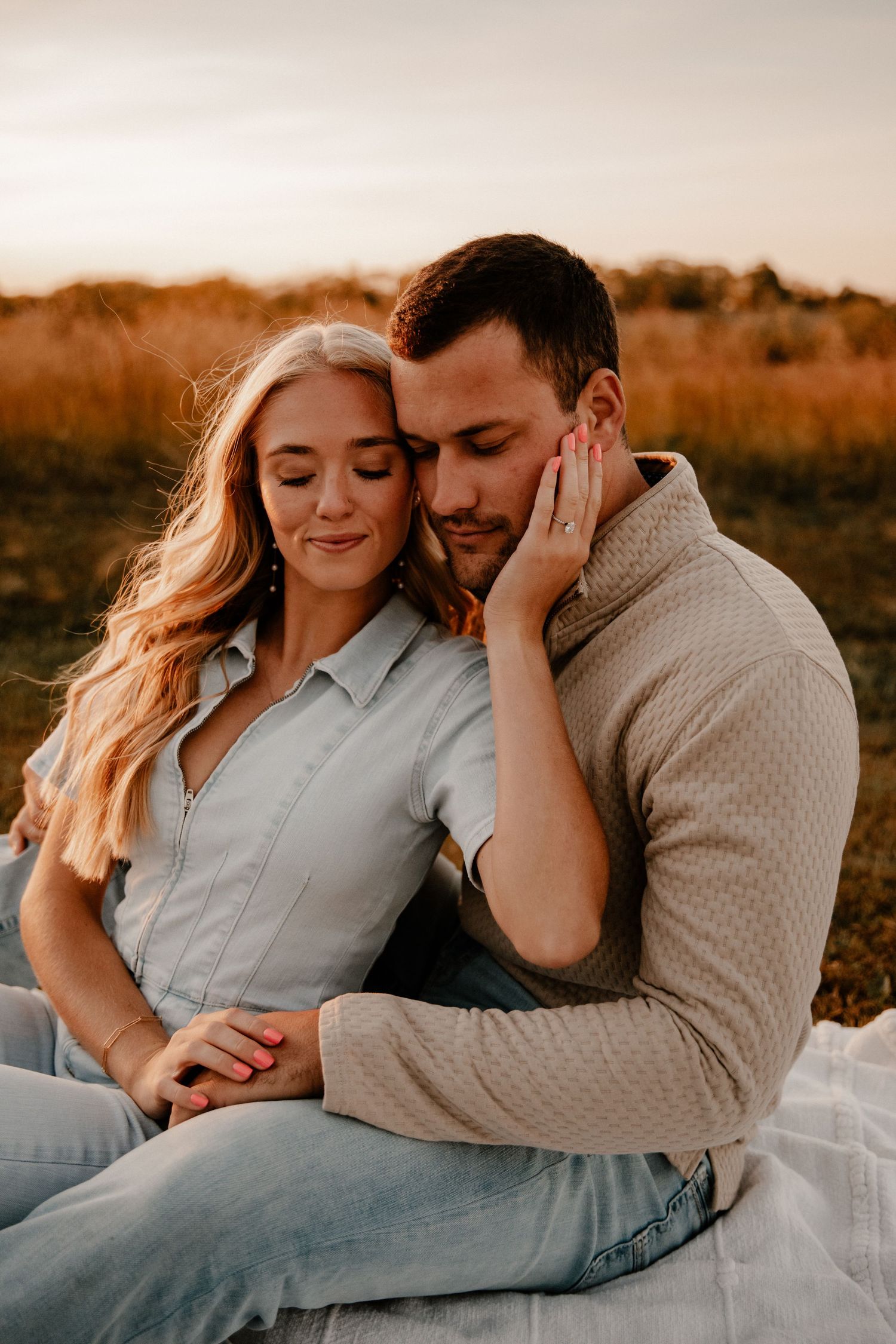 Intimate portrait of couple embracing during sunset engagement session.