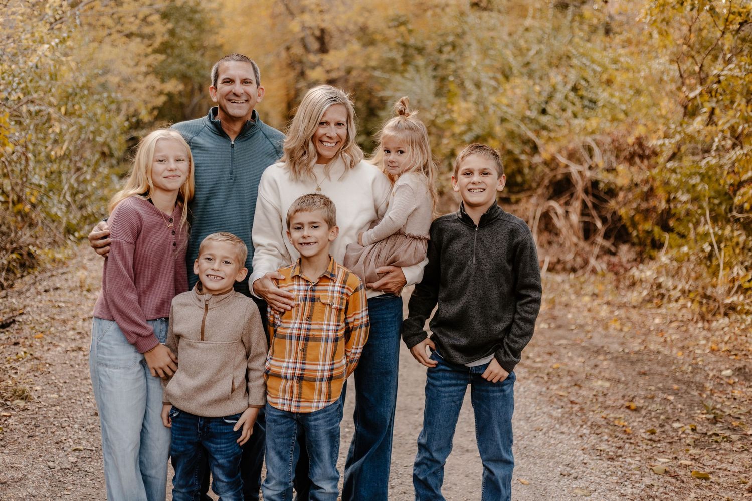 Family group photo session in autumn setting with warm earth tones.