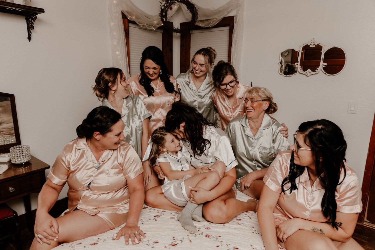 Wedding party gathered around table sharing laughter and conversation at reception.