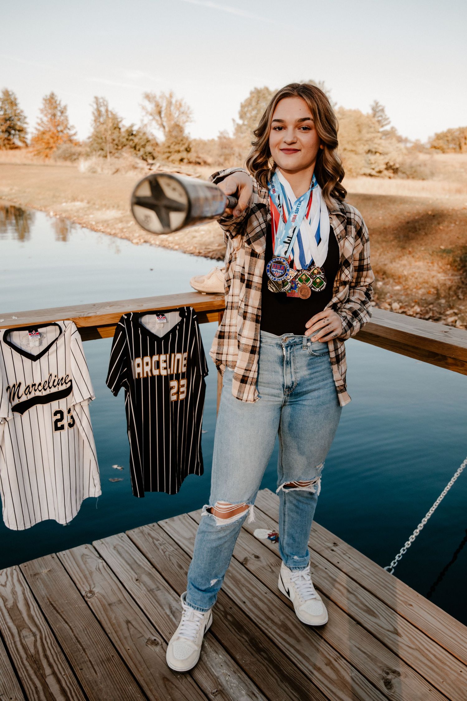 Baseball-themed photo shoot on wooden dock displaying various jerseys.