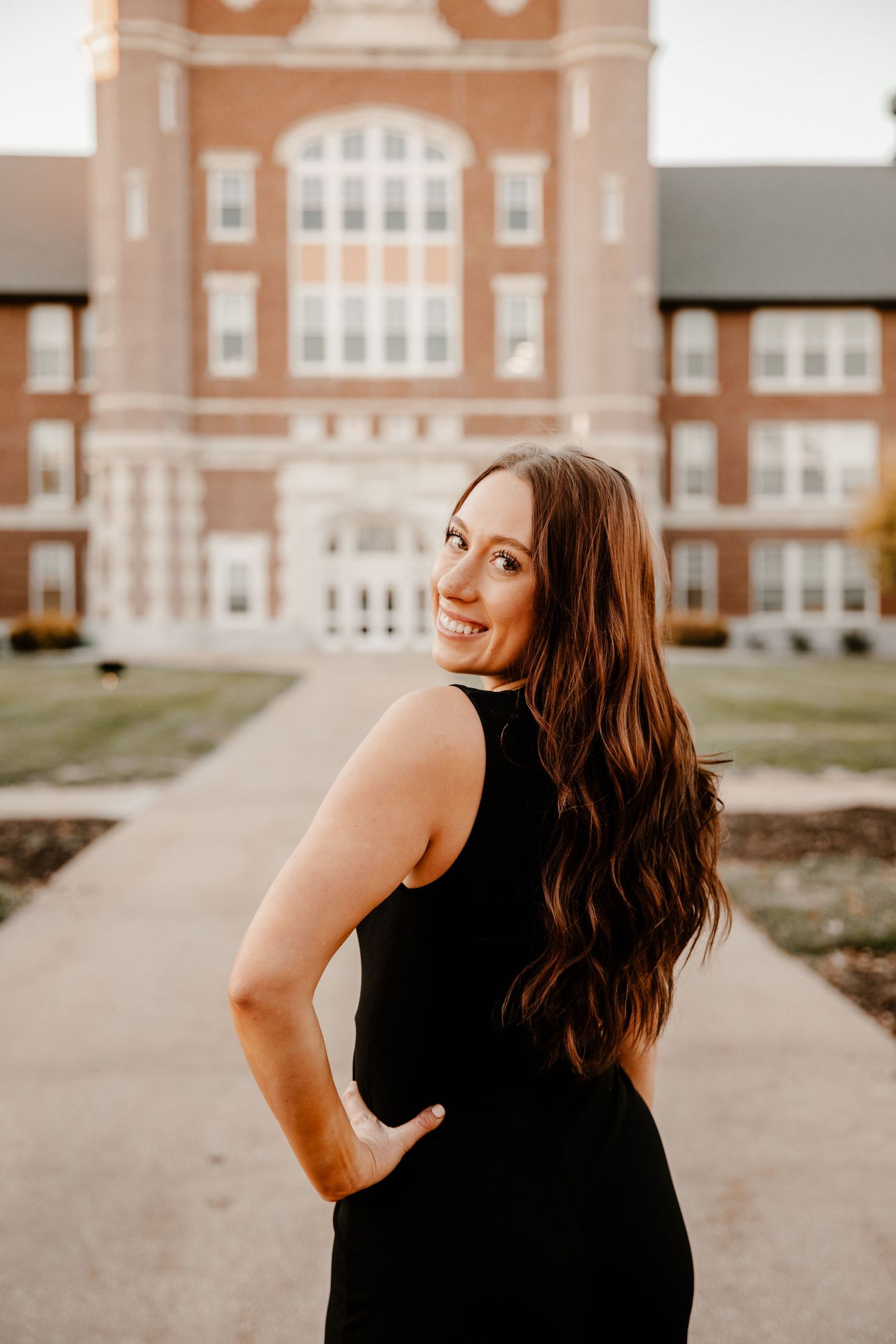 Portrait session outside a classic brick school building with architectural details.
