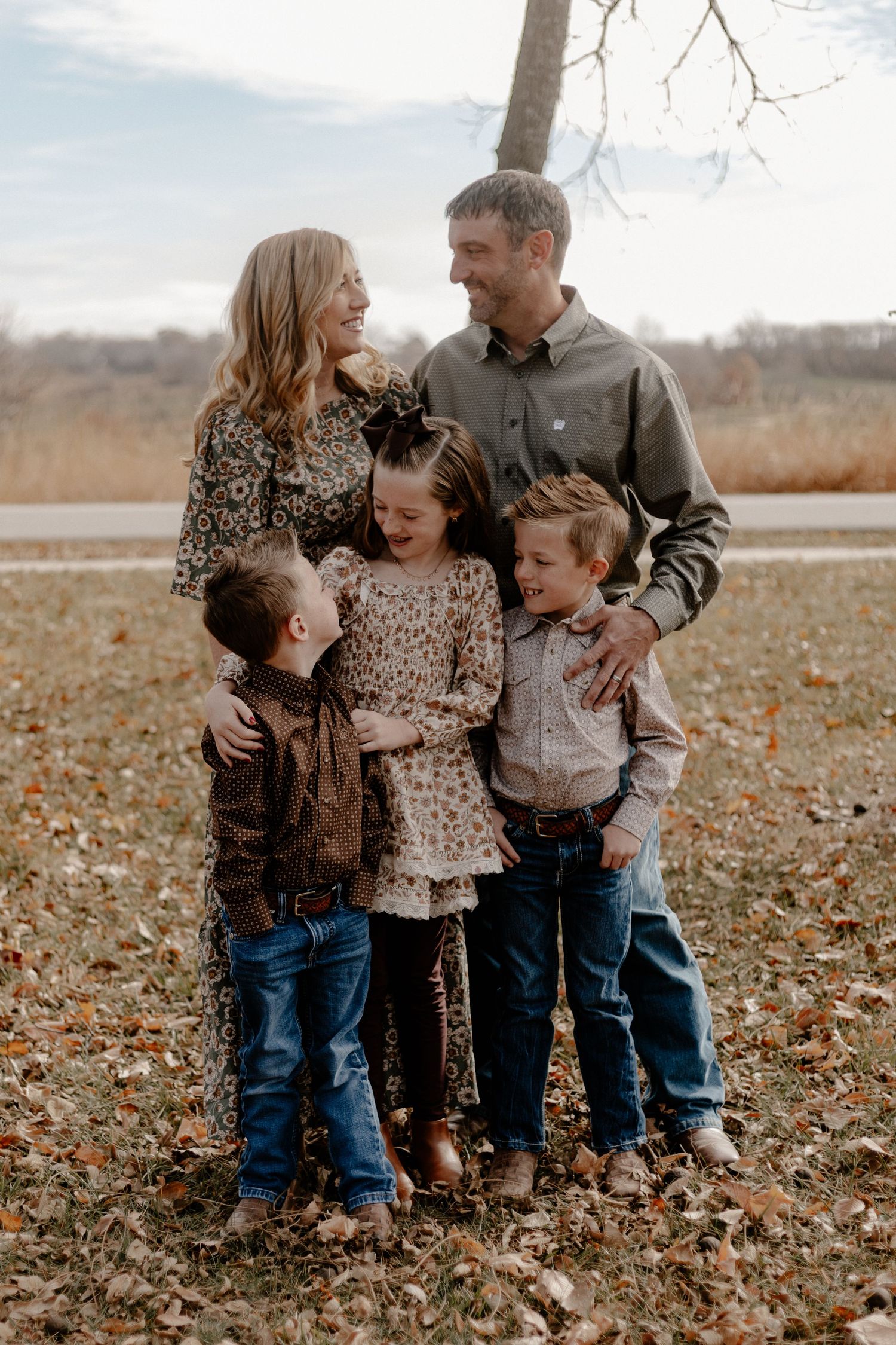 Family portrait series showing joyful moments in autumn leaves.