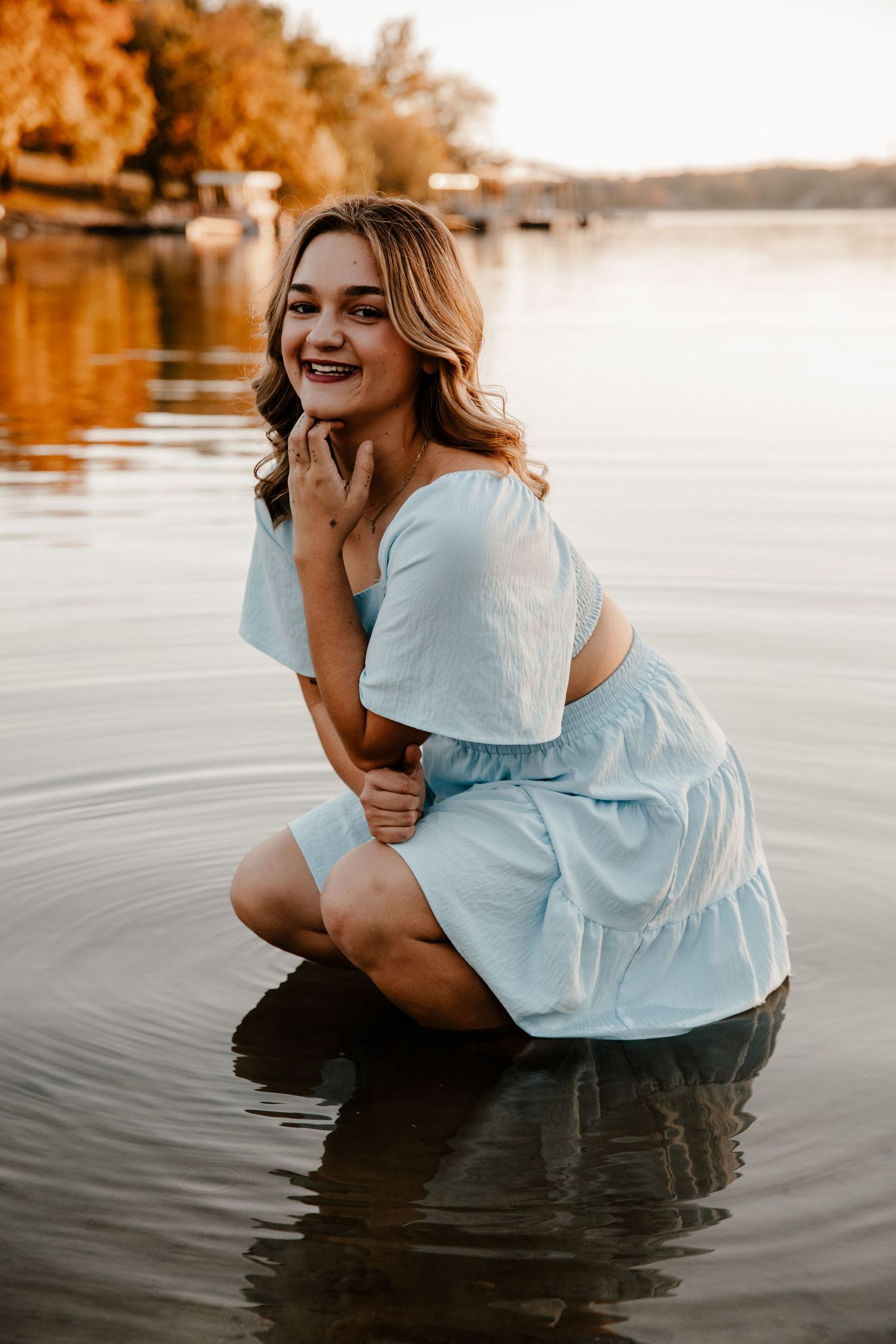Artistic water portrait in white flowing top during sunset at lake.