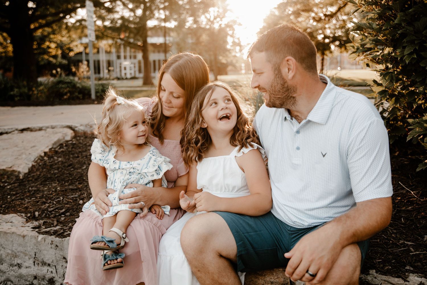 Family sharing joyful moment together during sunset outdoor portrait session.
