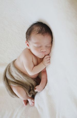 Bébé calme, paisible et endormi dans un écrin de douceur après son massage. Sa maman qui vient de le masser habite l'ouest lyonnais. Il dort