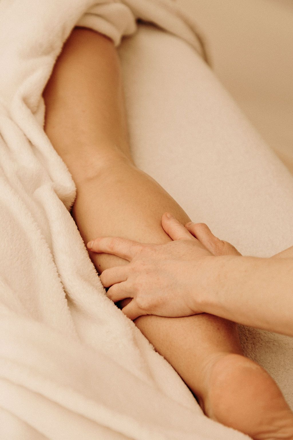 Juliette massant une jambe pendant un massage bien-être dans l'ouest lyonnais.
