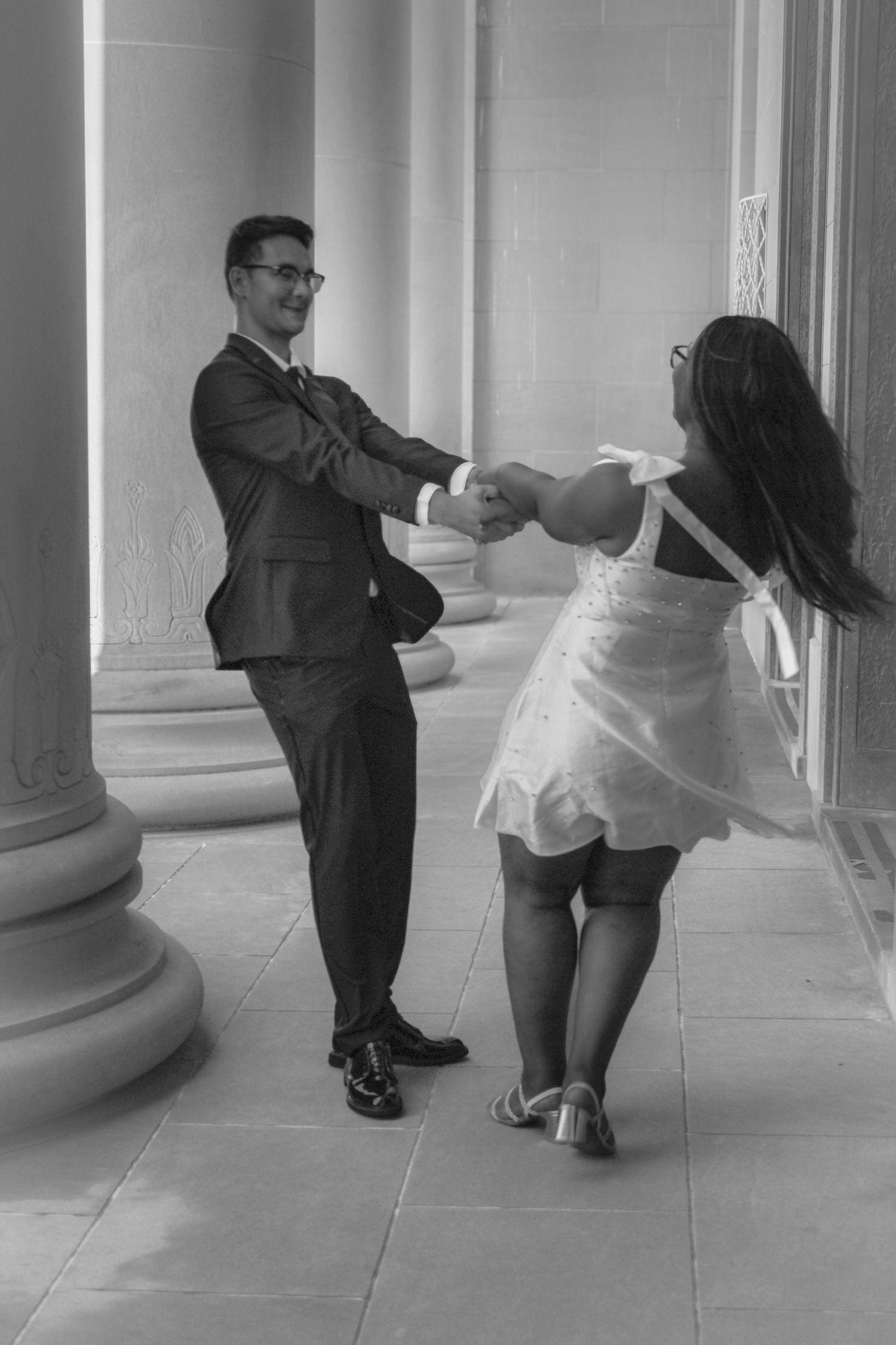 A series of black and white photos showing two people in formal attire dancing together in a columned hallway.