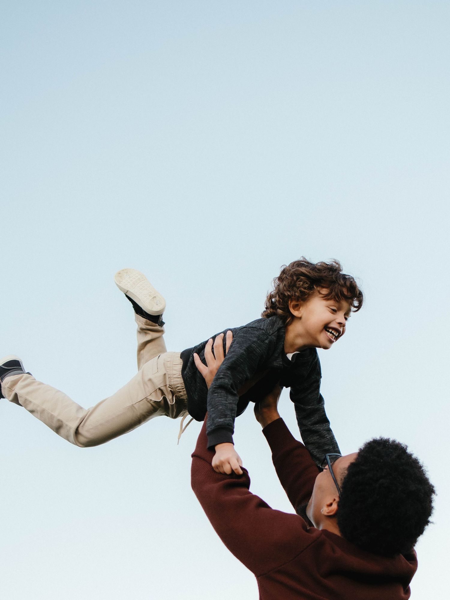 Father and son photography outside playing being thrown in the air- St. Louis family session