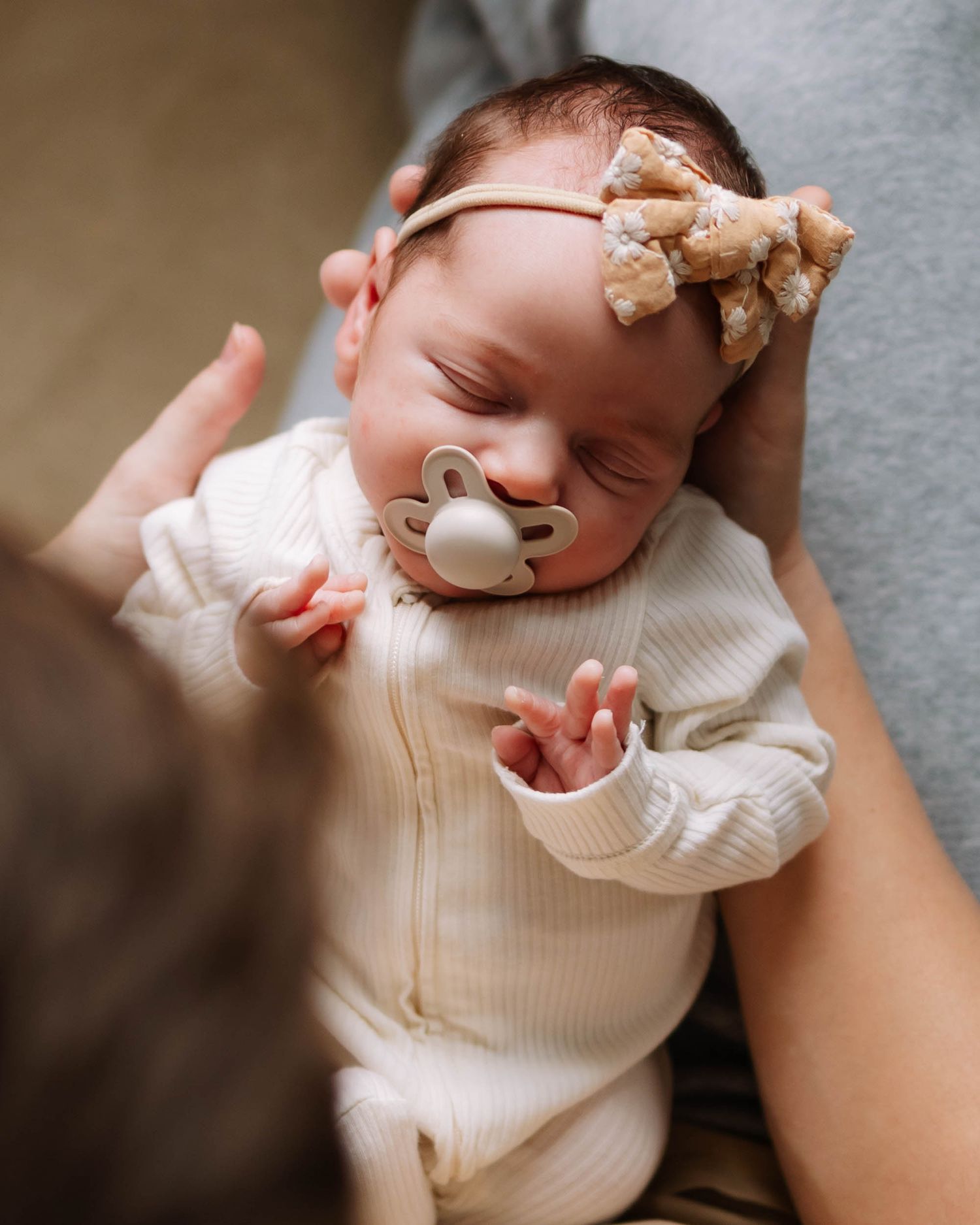 Newborn girl being held by dad by windows light in St. Louis, Missouri in-home newborn session