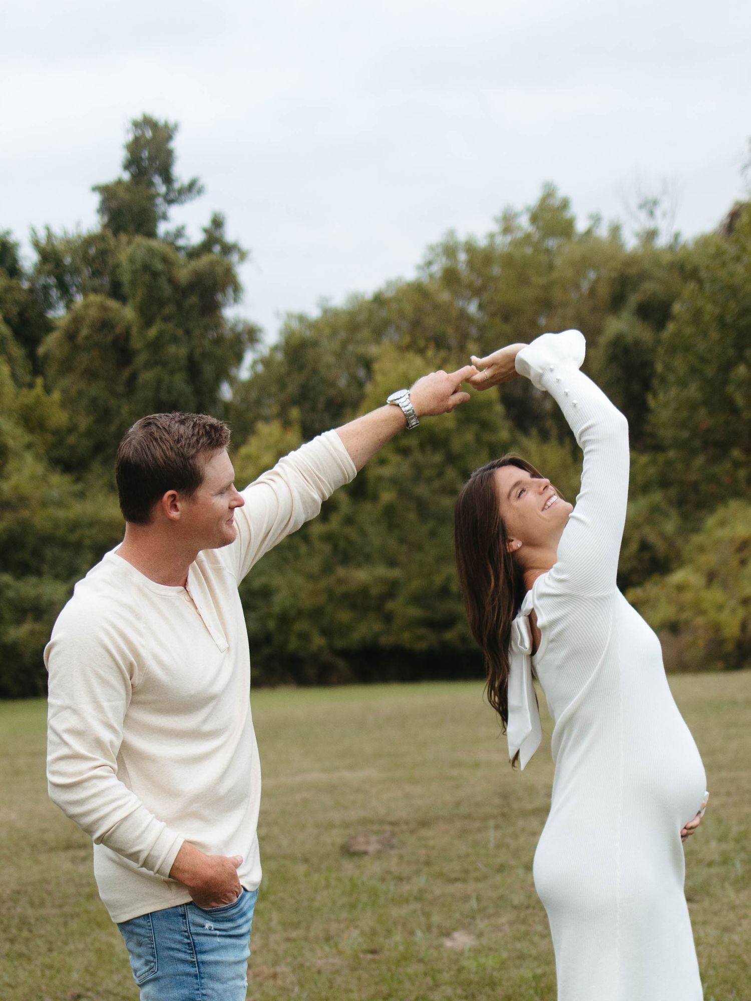 Expecting couple embracing the outdoors and dancing in the filed- St. Louis maternity session